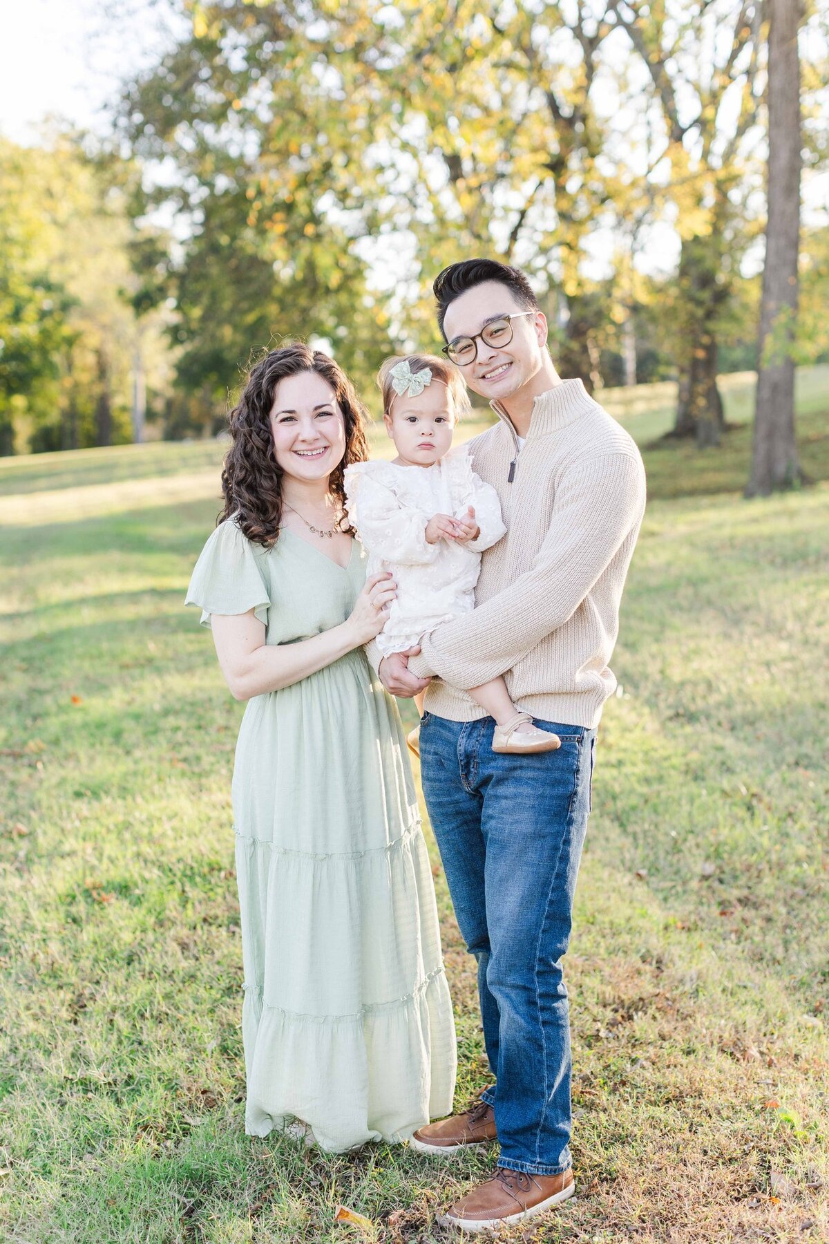 Mother, baby girl, and father smiling during spring in tennessee