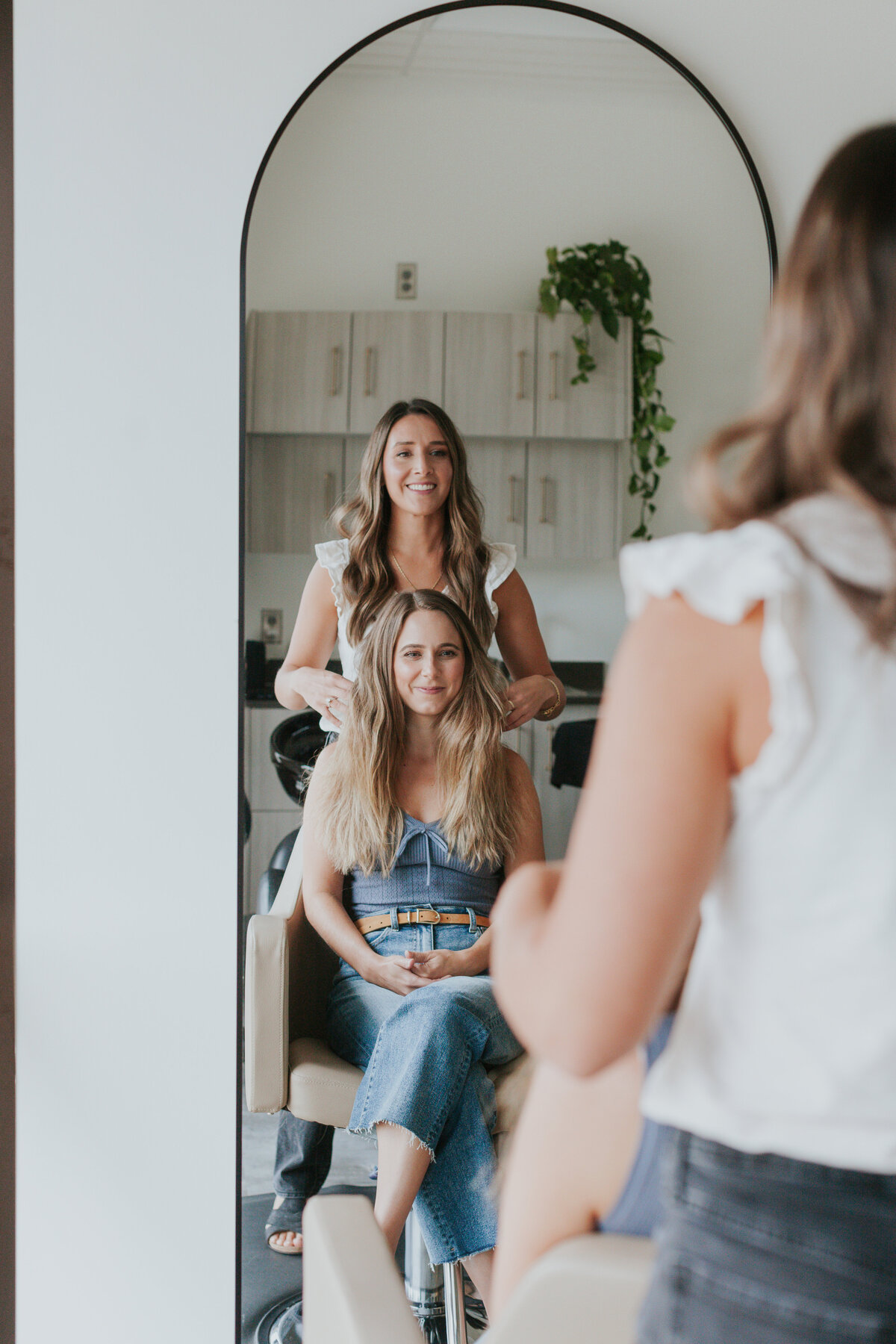 Brand photo of hair stylist Bekah Tutwiler of Aurora South Salon working with a salon client seen in mirror reflection