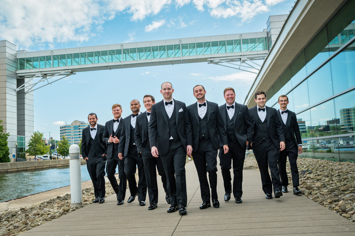 Groomsmen walking outside Erie Convention Center by Presque Isle Bay.