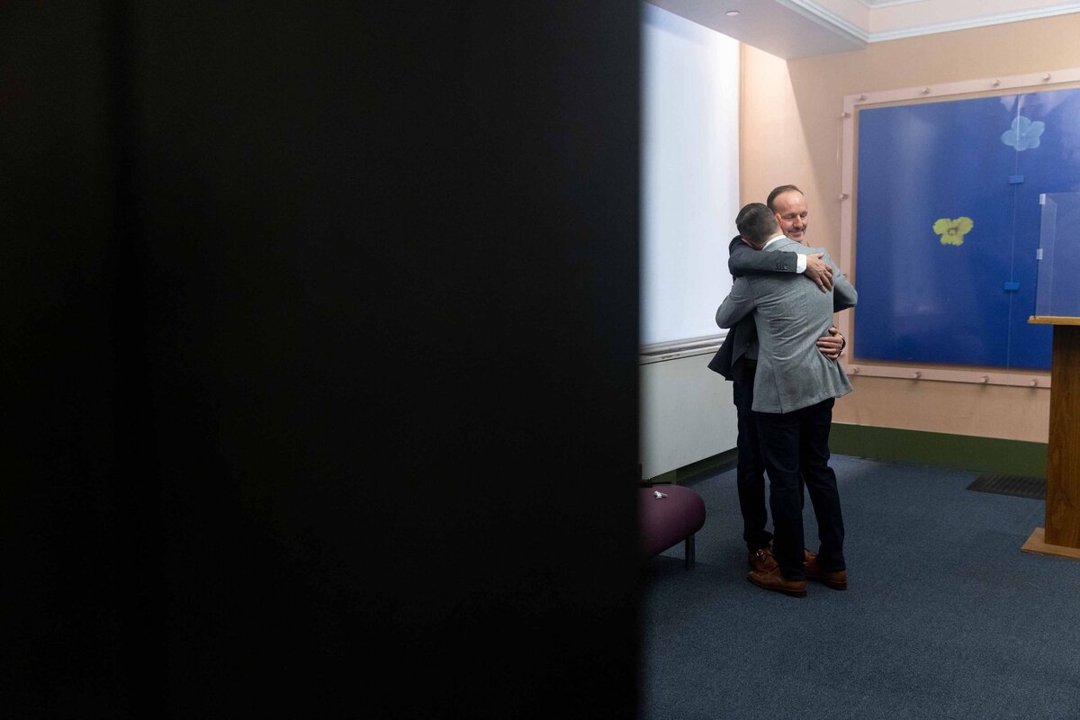 A couple hugging in a small room.