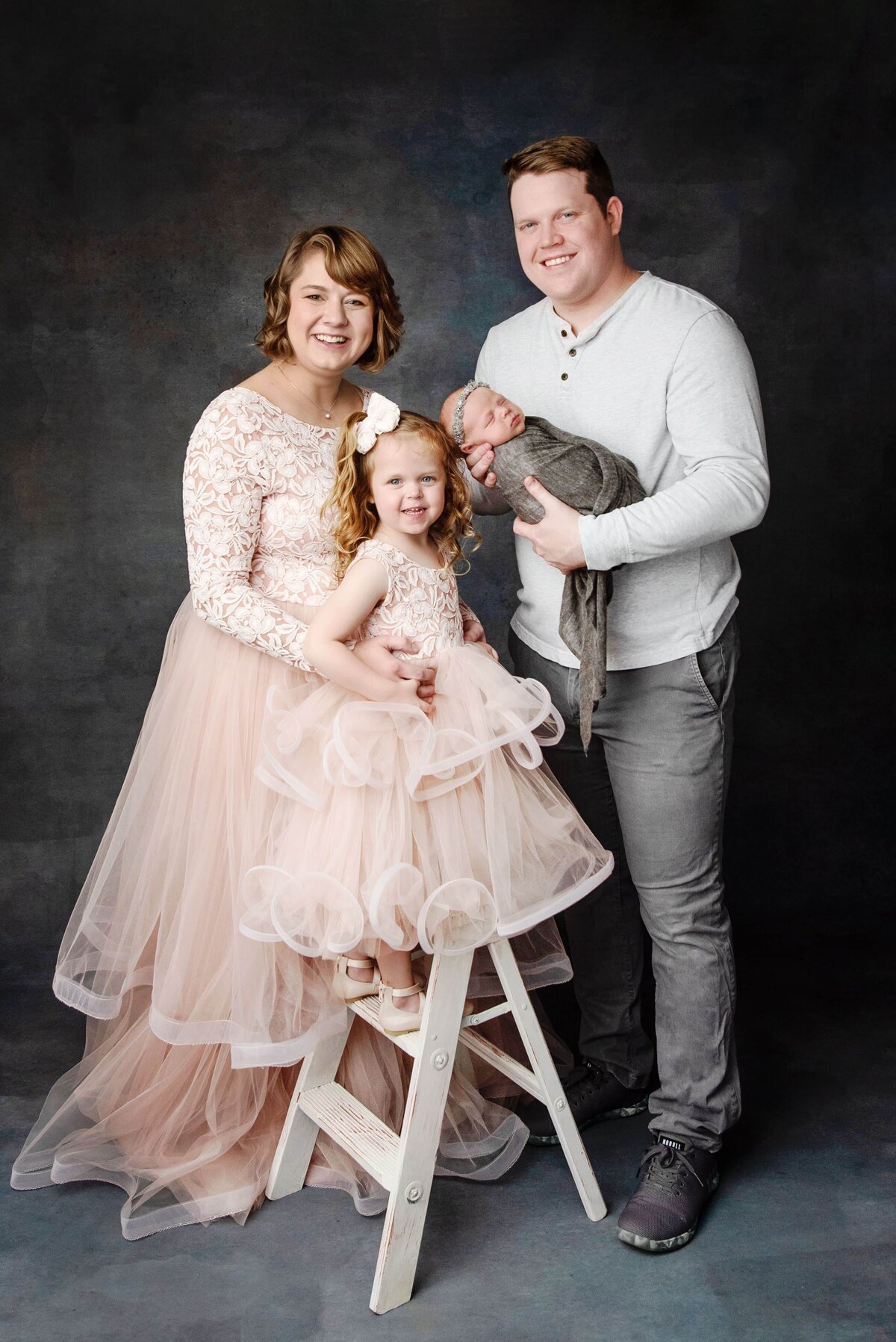 st-louis-newborn-photographer-mom-dad-big-siter-and-baby-family-picture-in-pink-gowns