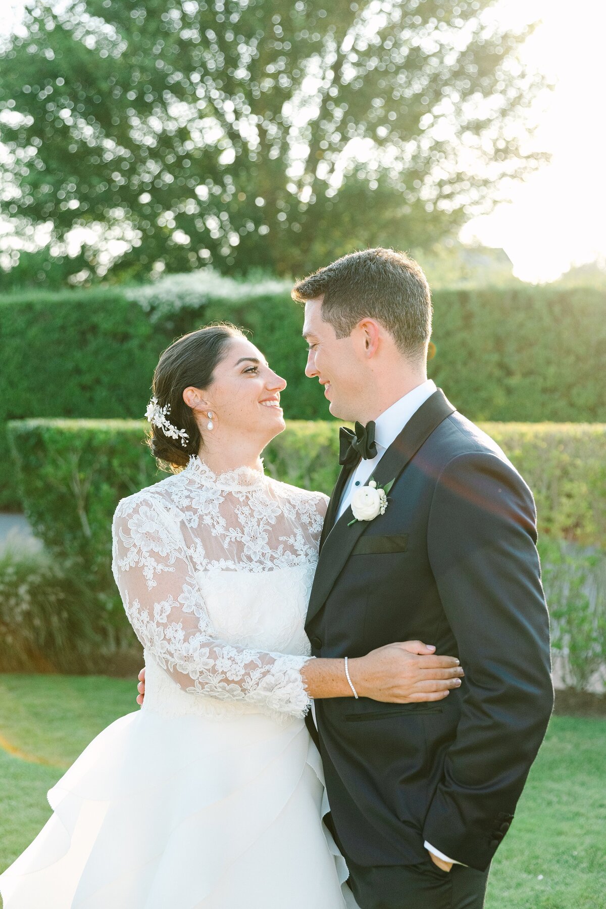 bride and groom smile at each other at sunset