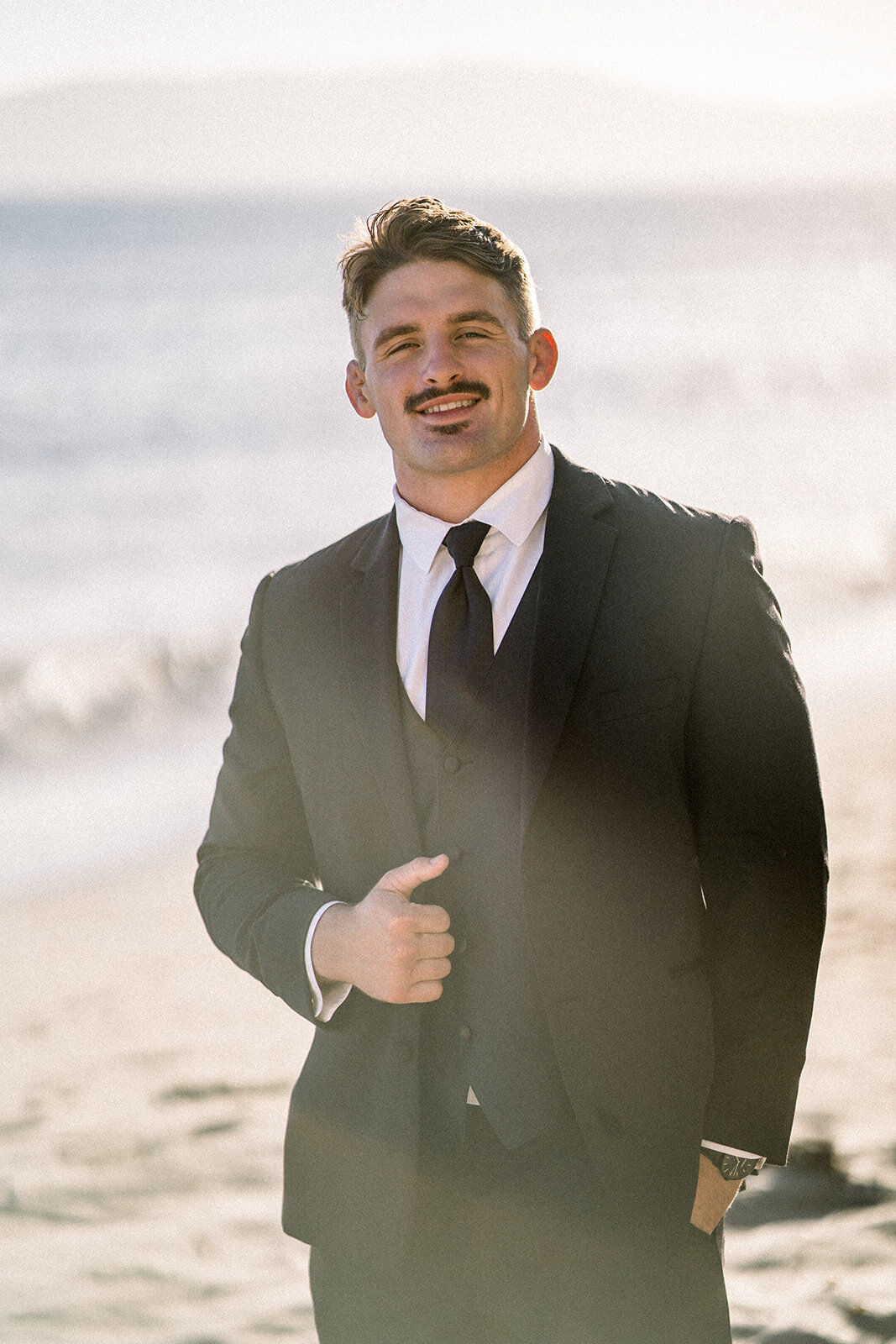 Groom on the beach at Dolphin Bay Resort in Pismo Beach, CA