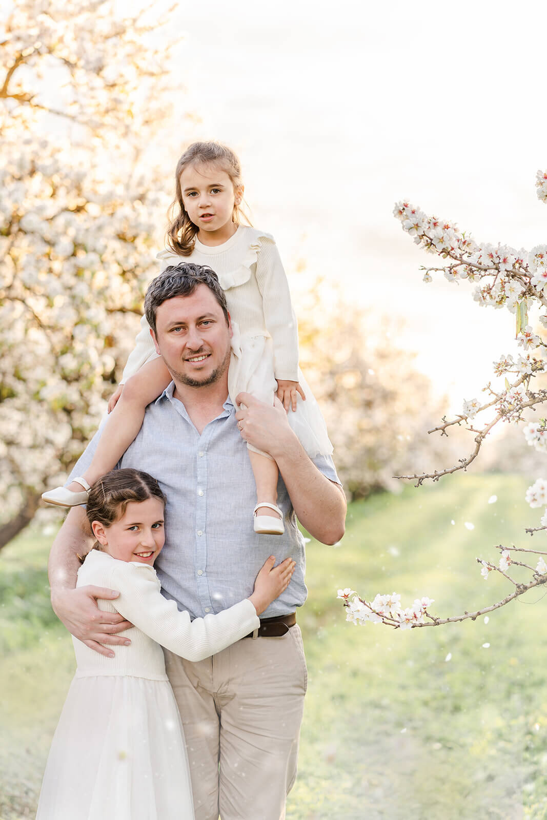 father and daughter portrait in white blossoms and dreamy light.