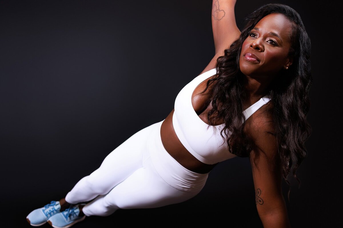 Woman leaning on table in front of pink backdrop