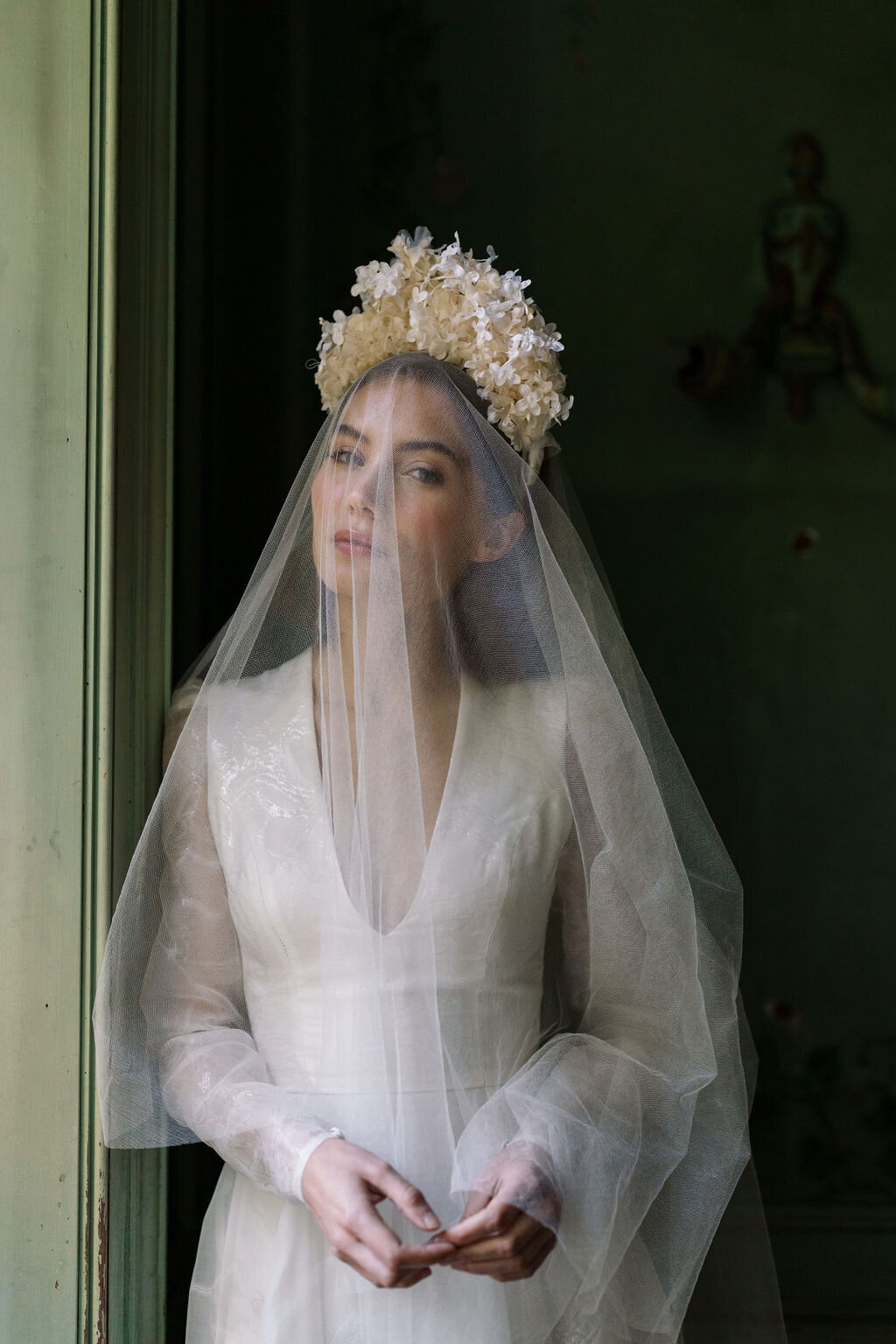 bride wearing wedding dress with a veil over her face
