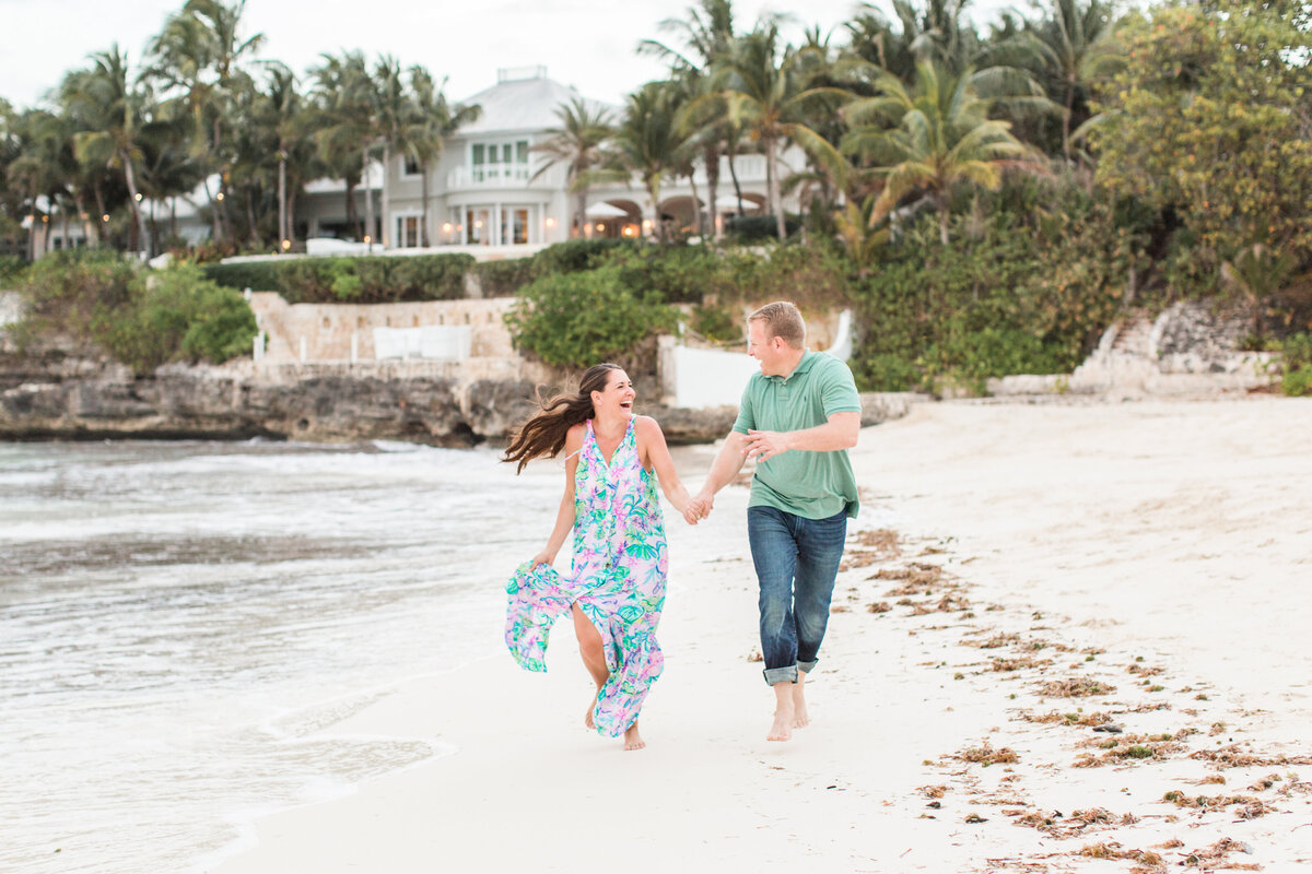 Couple running on the beach during engagement session