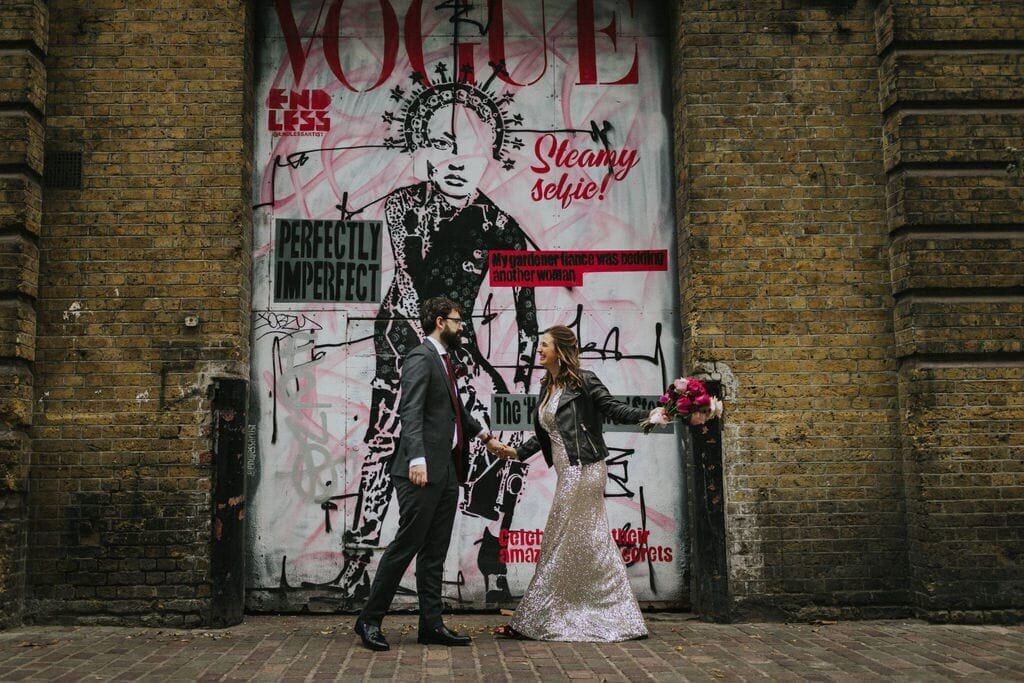 Bride and groom in front of grunge mural
