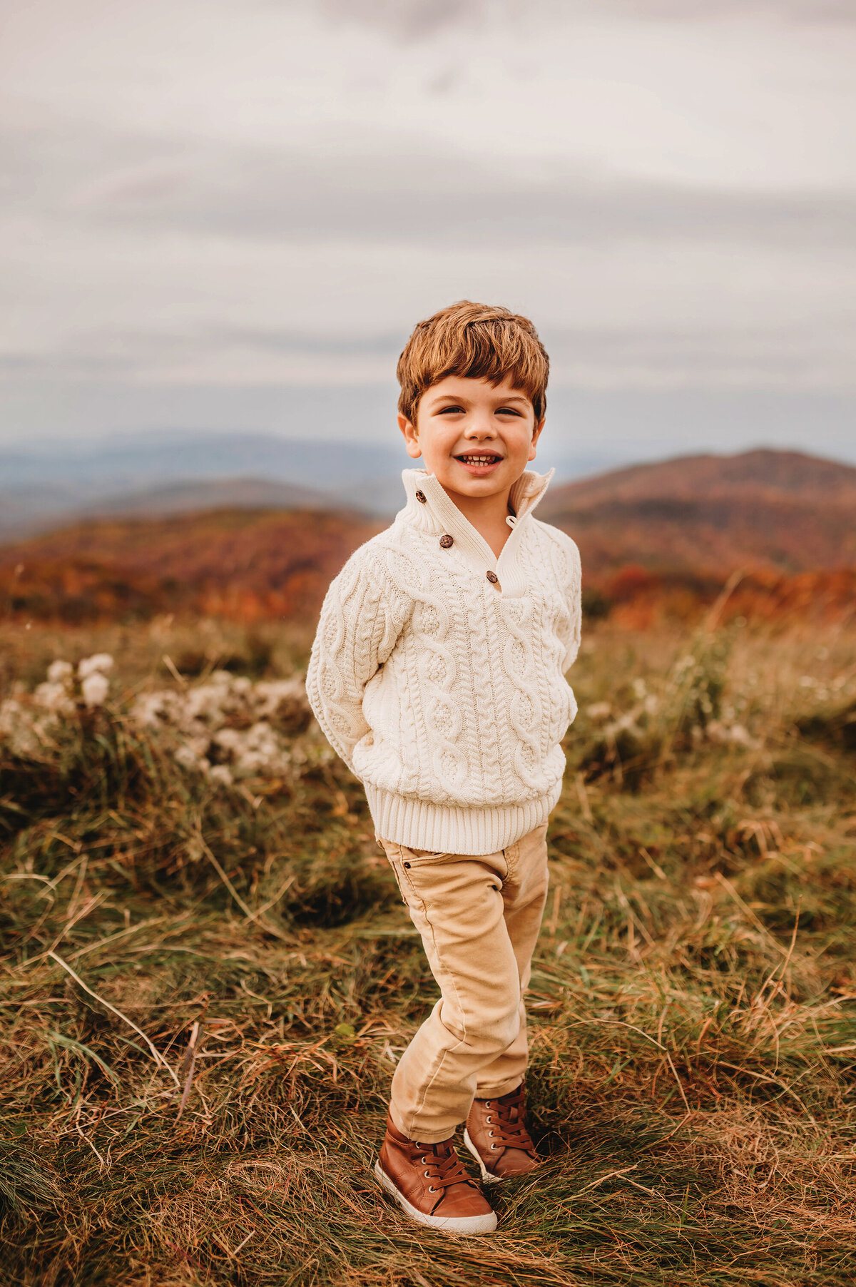 Little boy poses for portraits during Family Photoshoot at Max Patch in Asheville, NC.