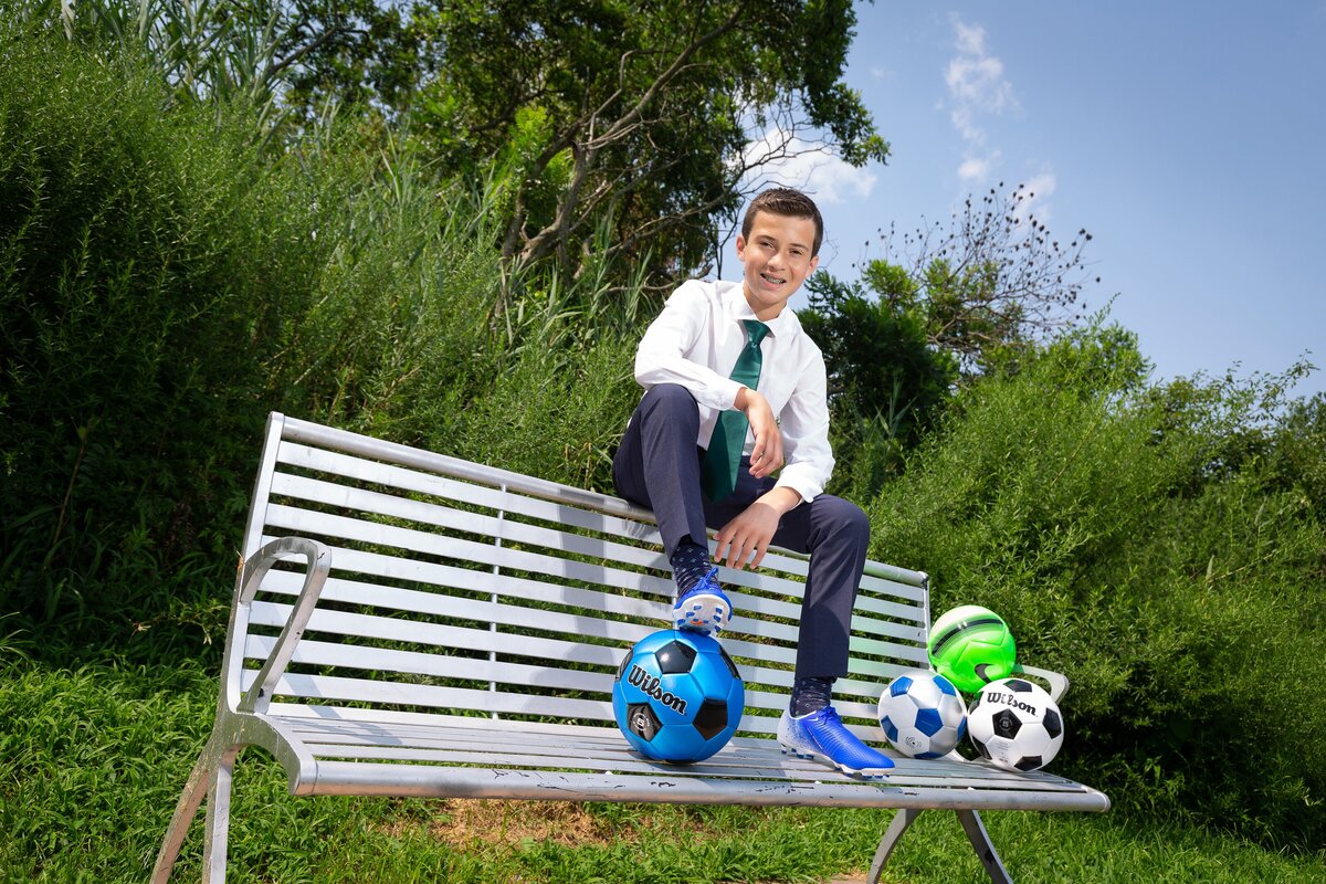bar-mitzvah-preshoot-boy-sitting-on-bench-soccerballs