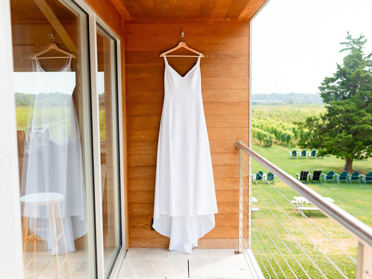Andria Bird wedding gown hanging outside at Saltwater Farms Vineyard.