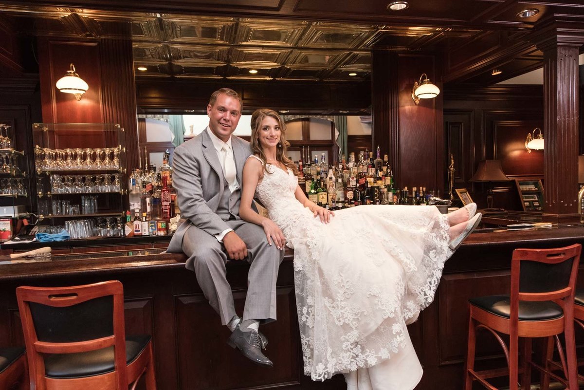 Bride and groom on the bar at The Mansion at Oyster Bay