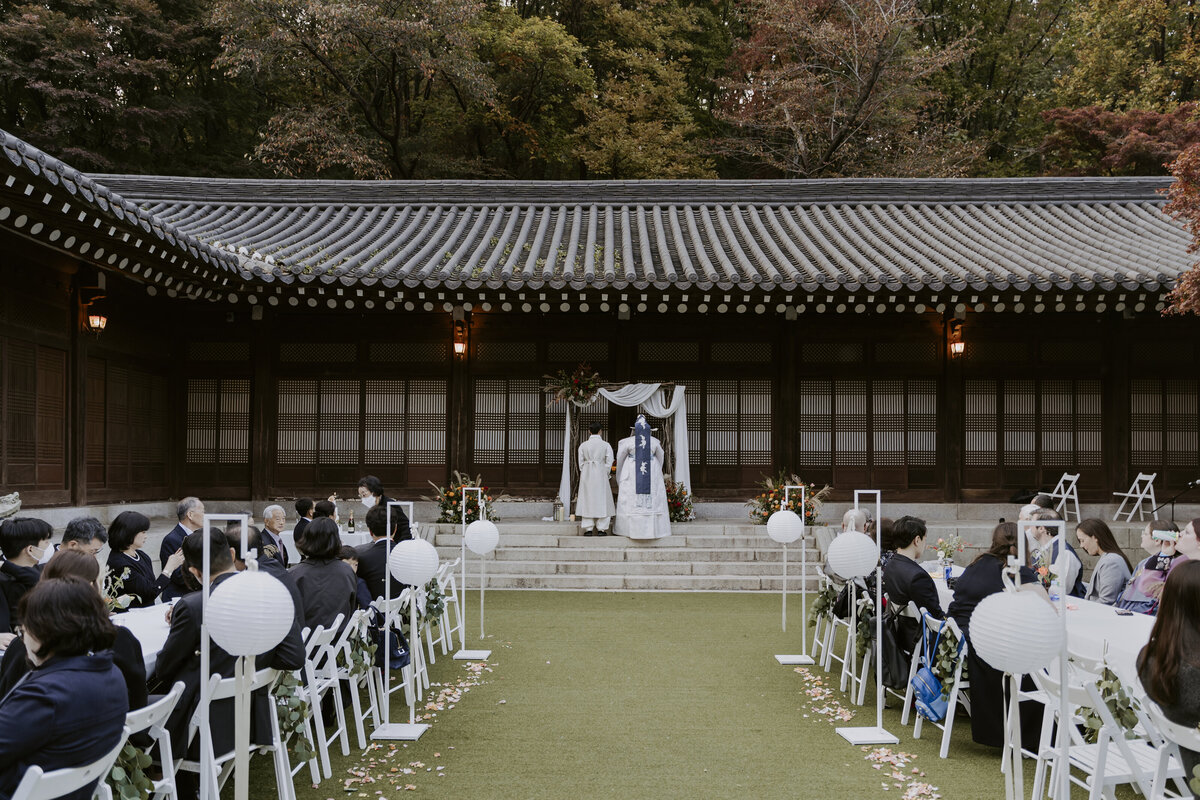 couple in white hanbok at the alter with the guests