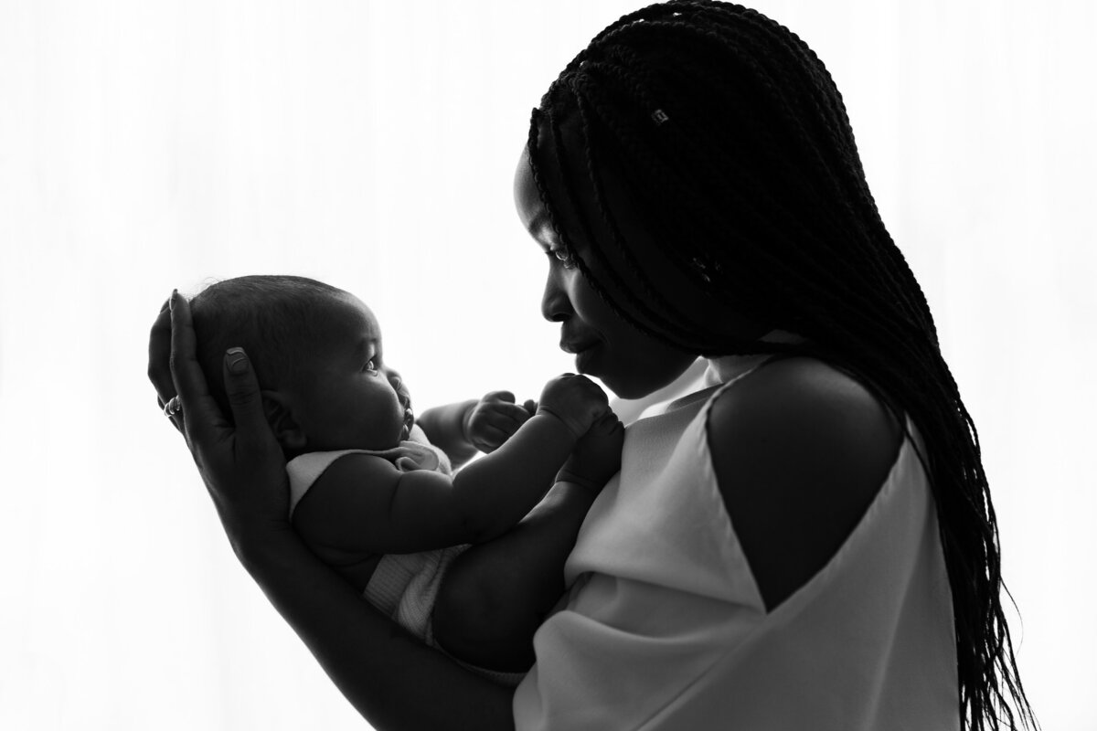 Silhouette of older baby and Mother in black and white during in-home session