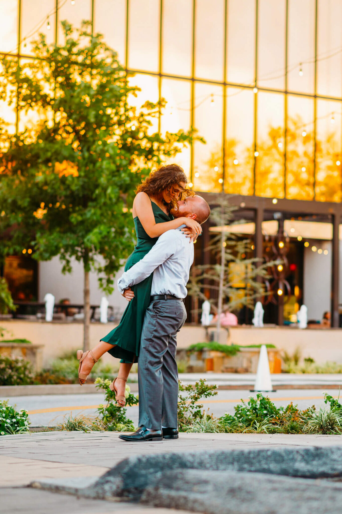 photo of a man picking up his fiancee in front of a fancy hotel