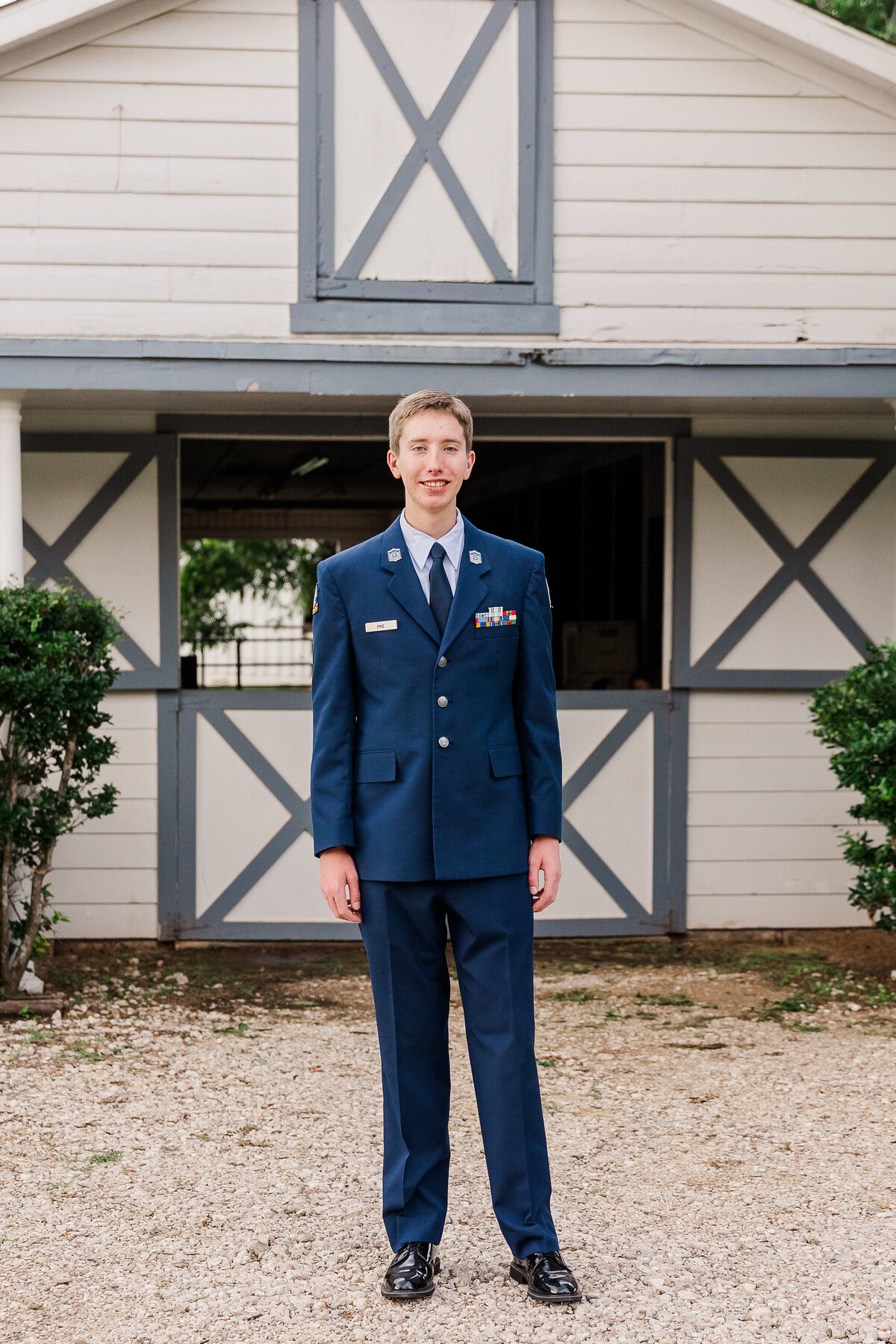 Man in uniform in front of barn