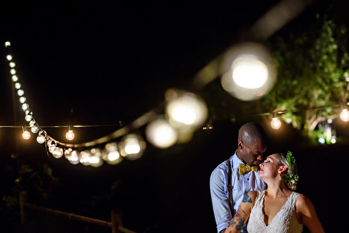 A wedding couple kiss under the string lights at their Baltimore Wedding.
