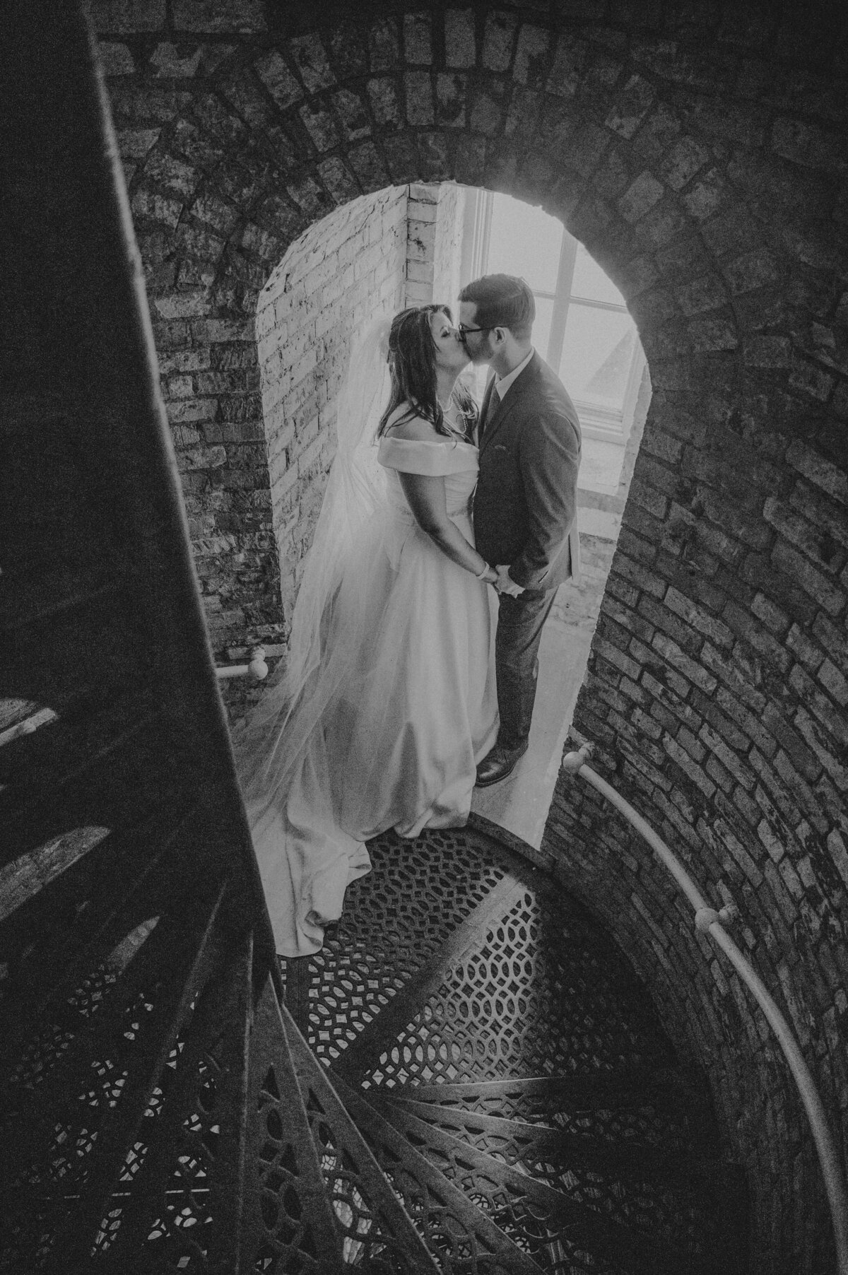 Bride and groom  kissing in a staircase