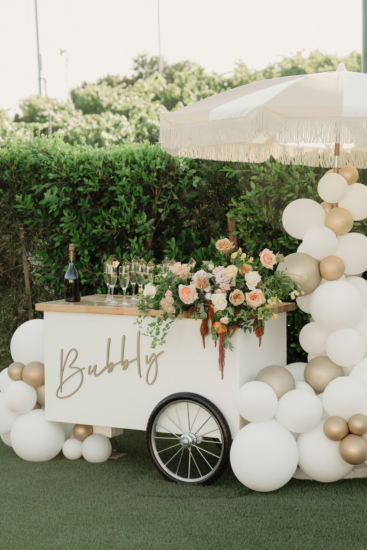 A champagne cart decorated with a large bouquet of flowers.