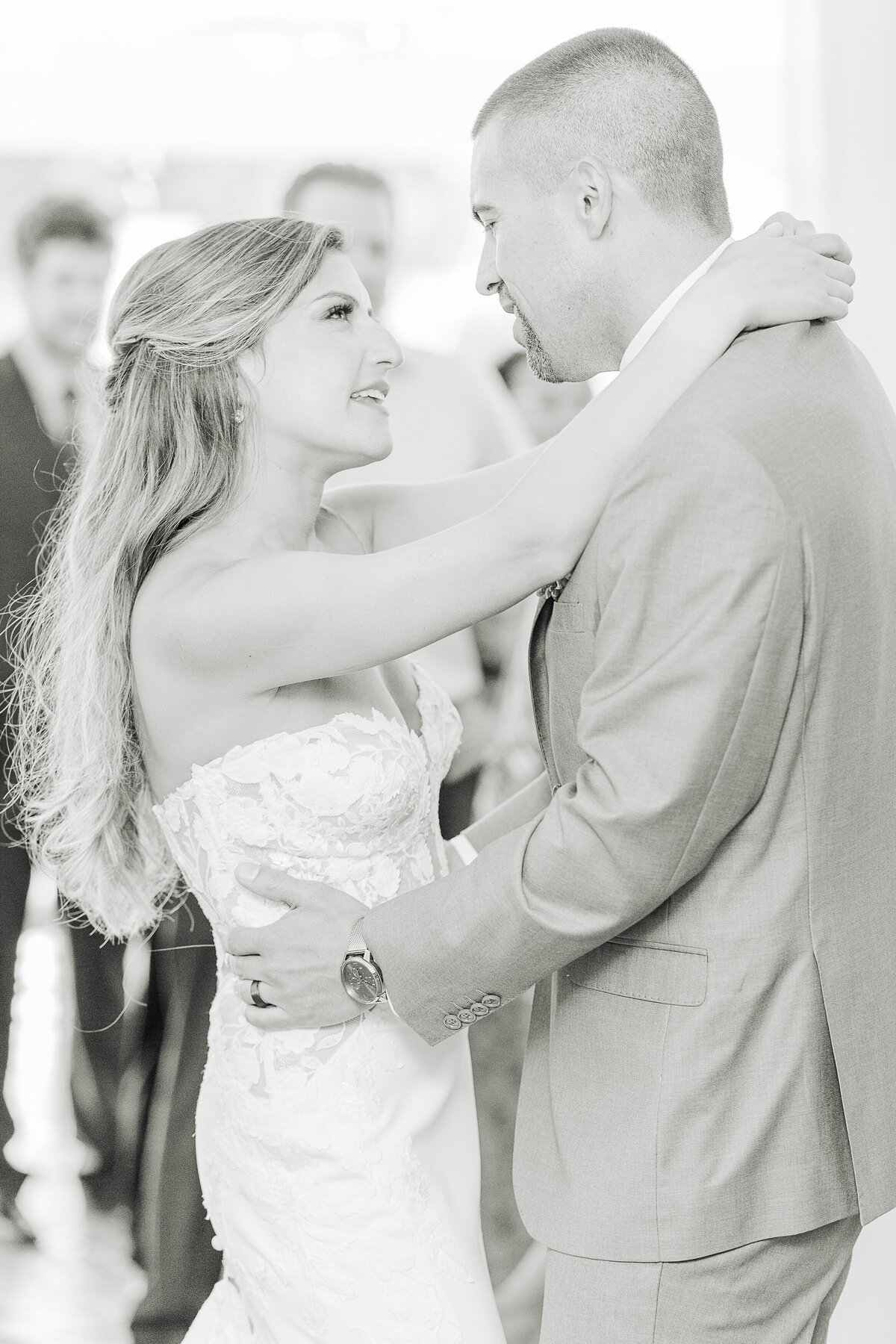 Bride and groom share a dance at their Five Bridge Inn Wedding Reception. Close up image. Bride's arms are draped around her groom's neck. They are looking and smiling at each other. Captured by MA wedding photographer Lia Rose Weddings