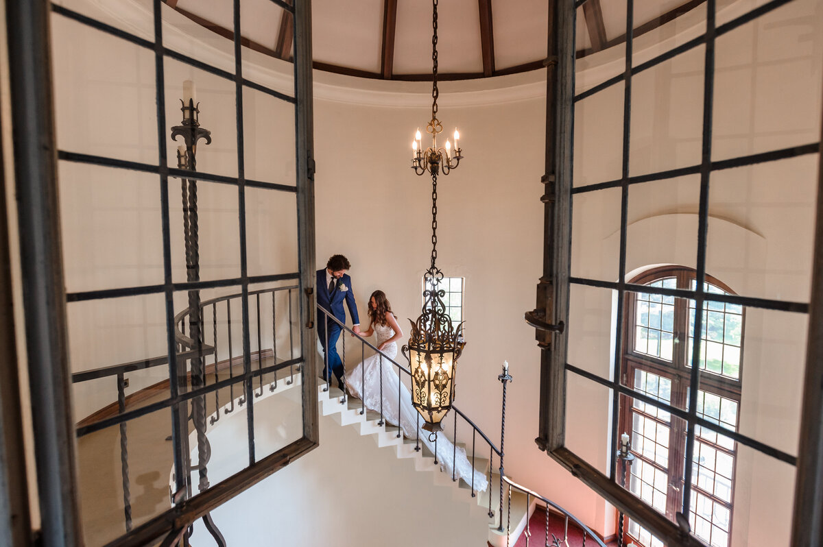 Bride and groom walk up stairs at Ewing Cultural Center