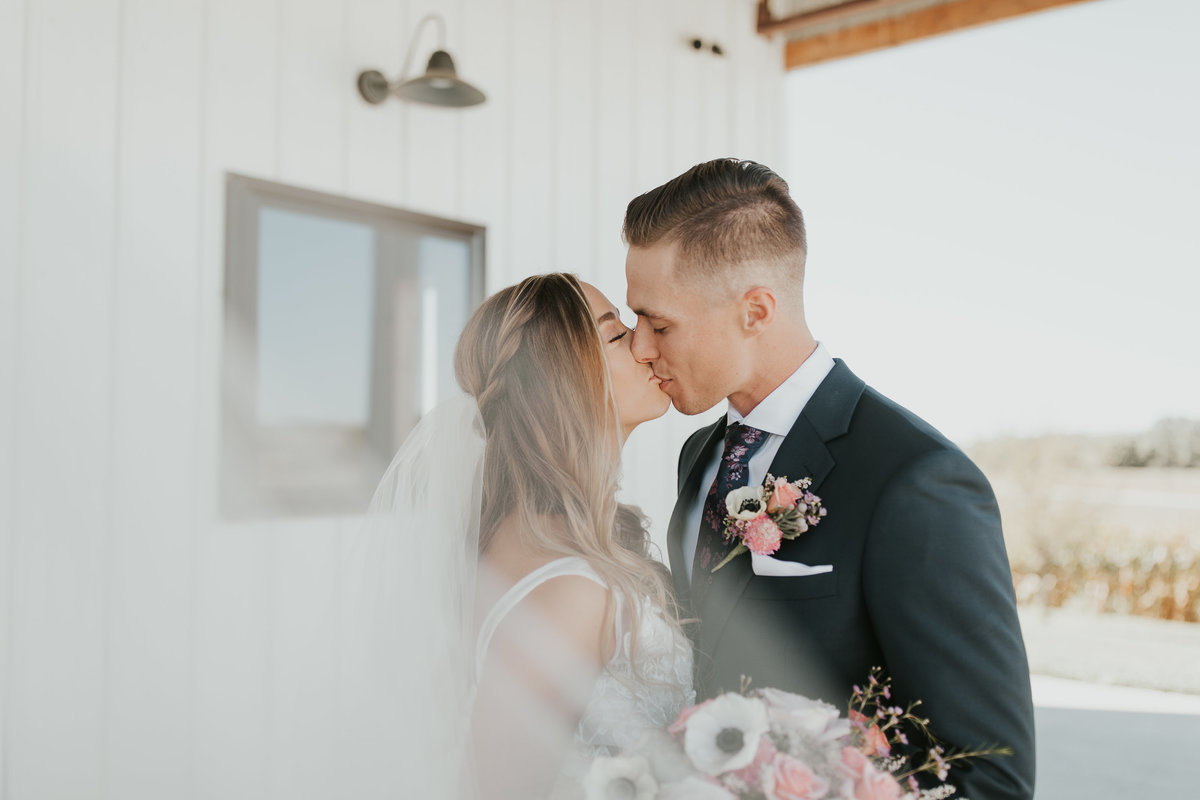 Bride and Groom kissing during their Romantic Wedding at Wishing Hills Barn in Missouri Valley, Iowa