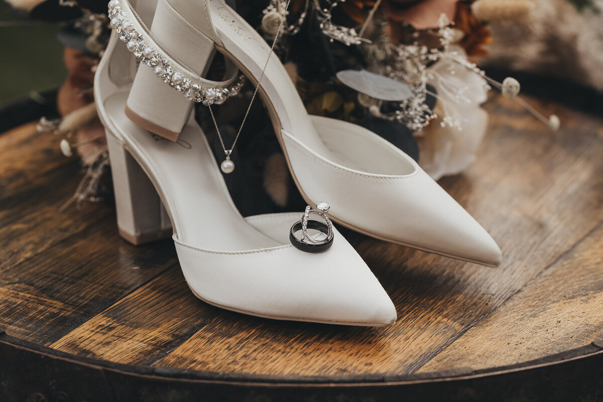 bridal shoes with flowers and wedding ring