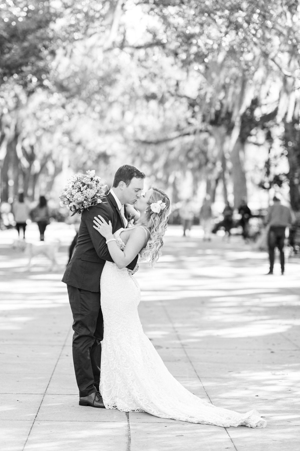 black and white image of bride and groom embracing and kissing