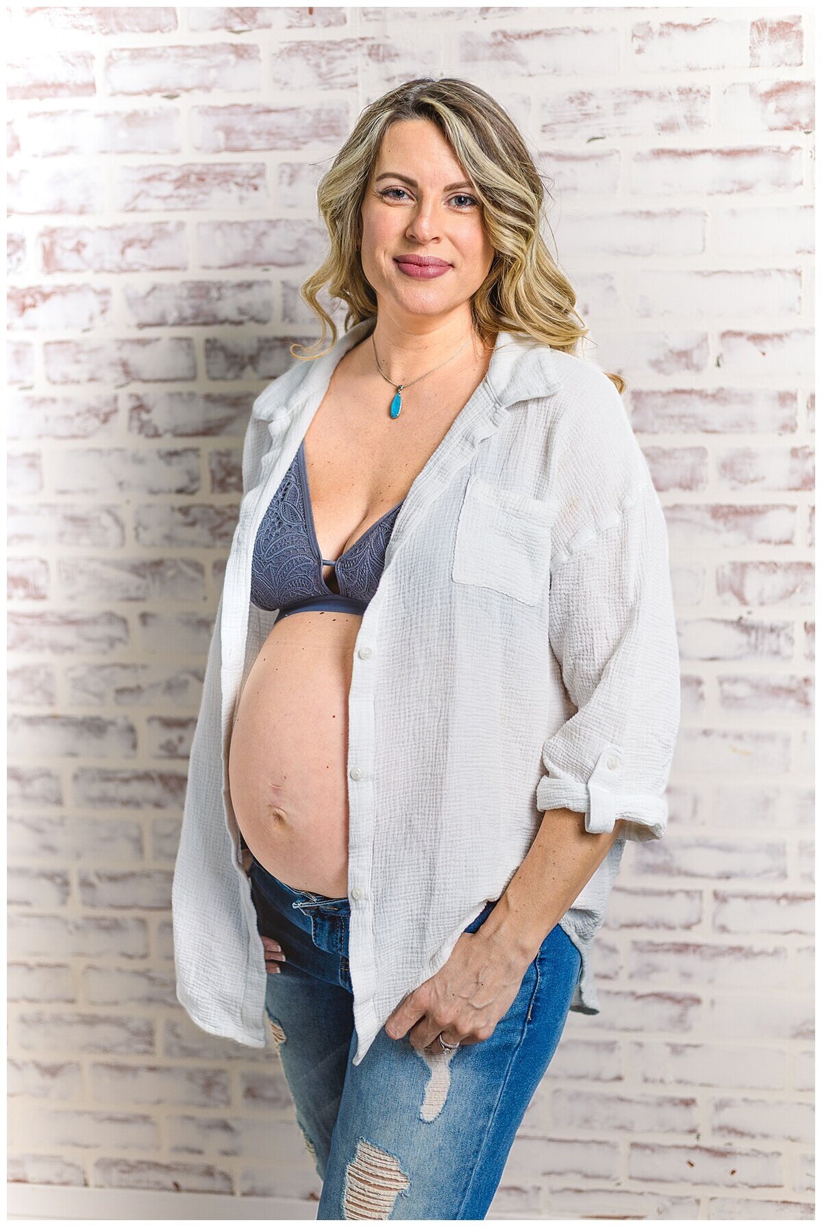 Mom to be showing off her beautiful baby bump in a cute top and jeans during a maternity photoshoot in studio in Wexford PA