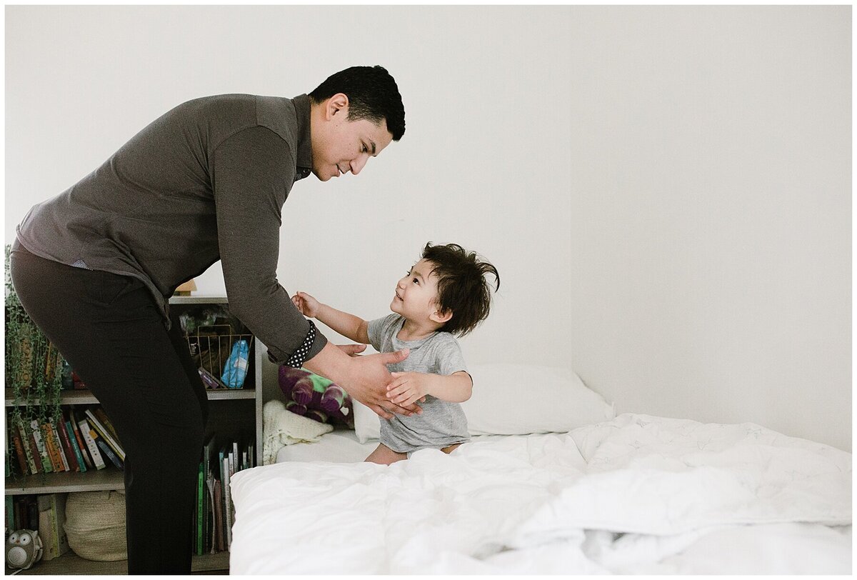 Dad picking child up from bed at family photo session in Austin by Amber Vickey Photography