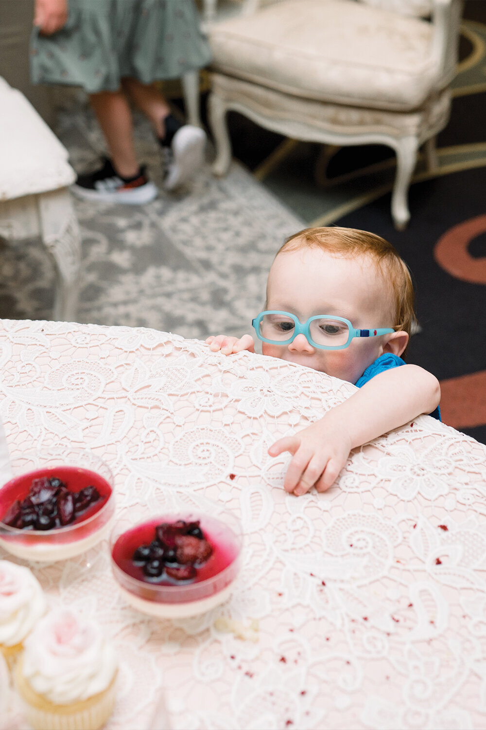 Young boy reaching for a dessert at a 50th wedding anniversary celebration, just peeking over the top of the dessert table. This charming moment adds a touch of warmth and joy to the event at The Northern Hotel in Billings, MT.