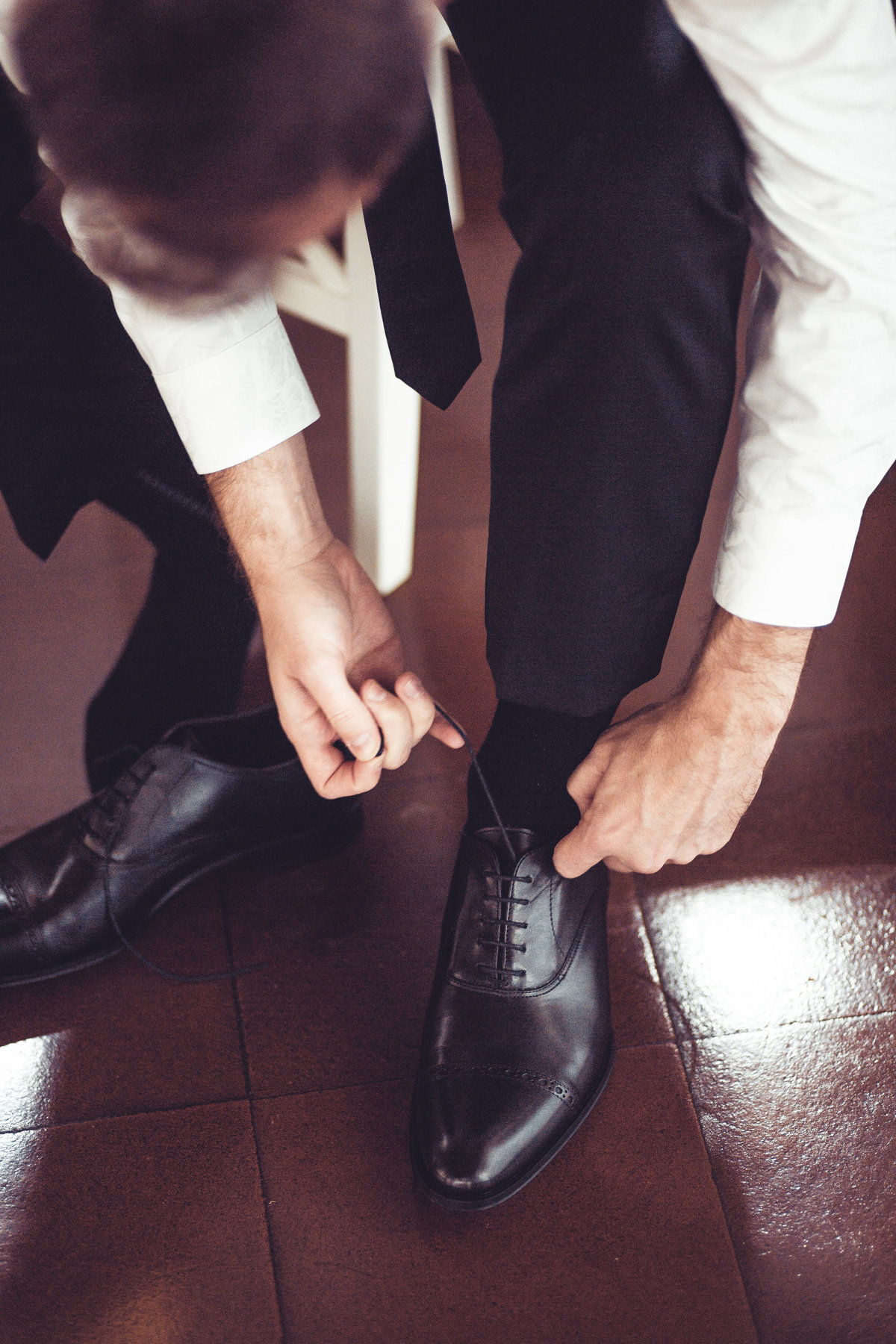 Groom Tying Shoes Photography