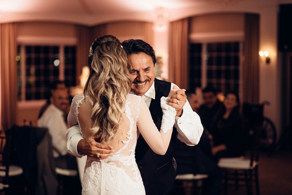 Wedding Photograph Of Man In Black Suit Smiling While Dancing With Bride Los Angeles