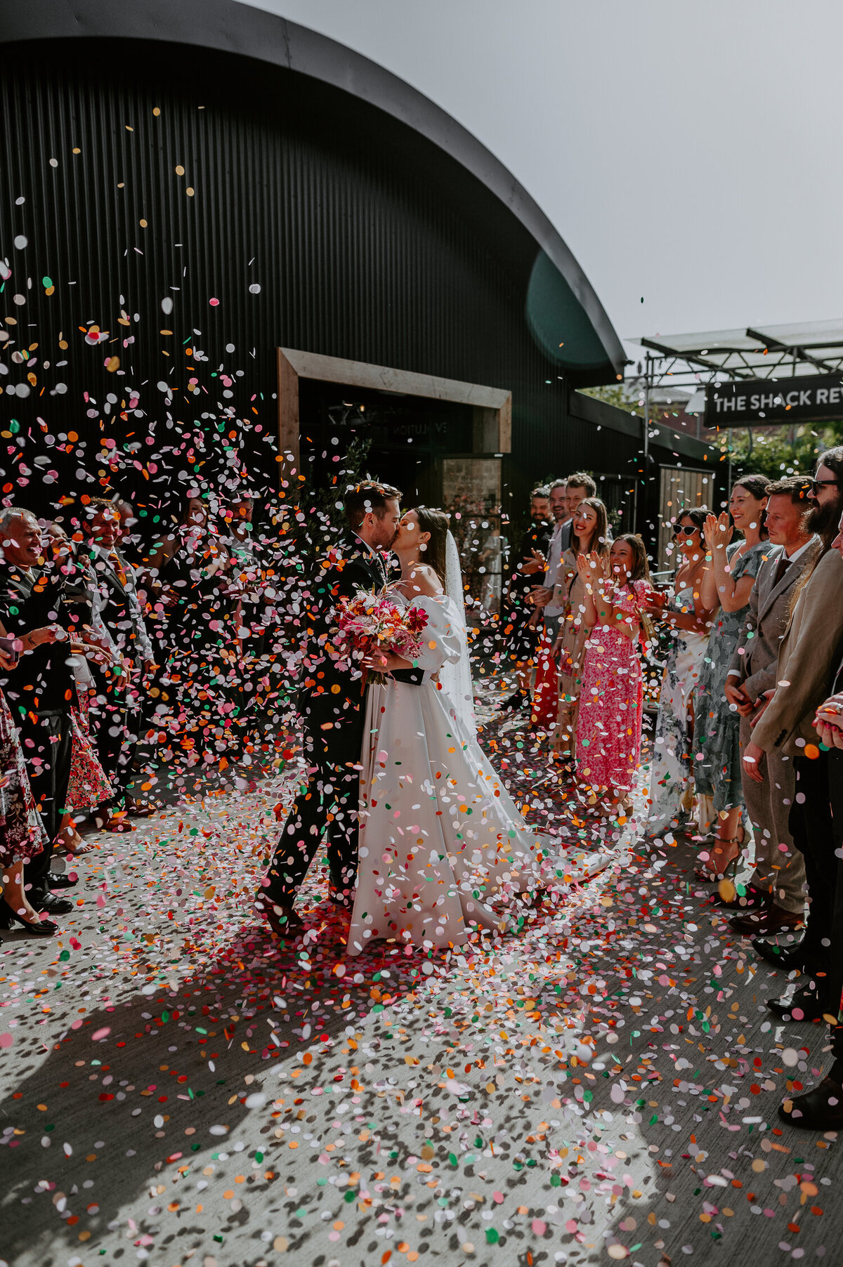 Guests throw confetti over a ride and groom outside the Shack Revolution in Hereford.