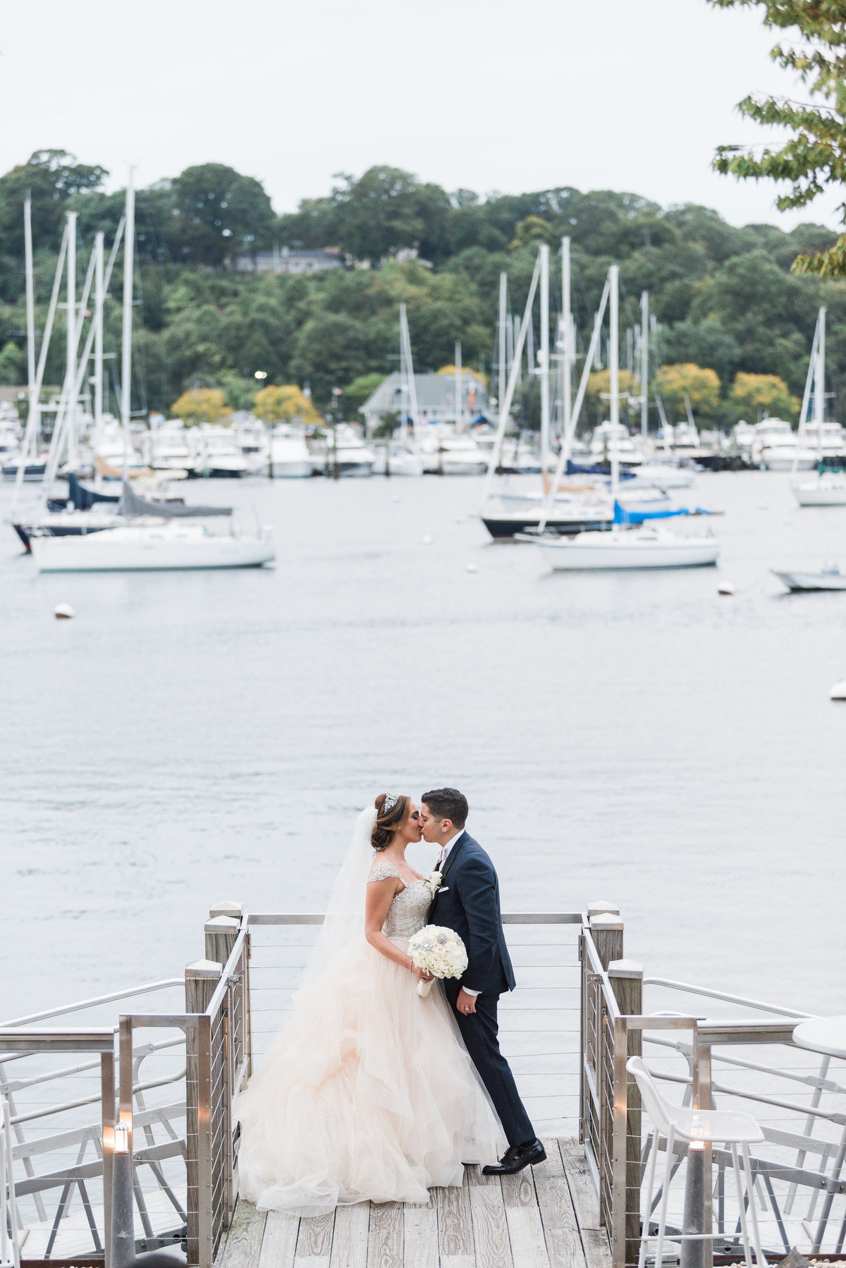 Bride and groom kissing at the dock at Prime