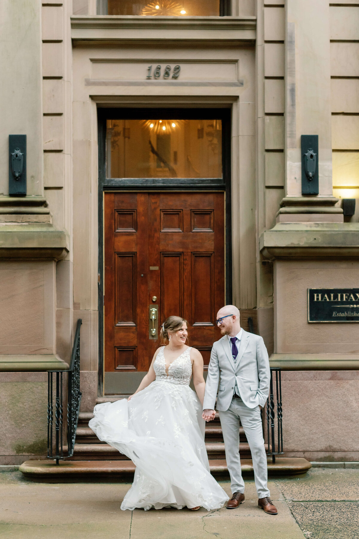 Bride and groom standing outside a large door at  at Halifax Club wedding in Nova Scotia