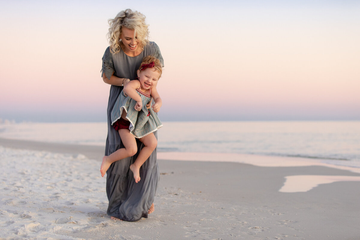 A mom holding up and playing with their child