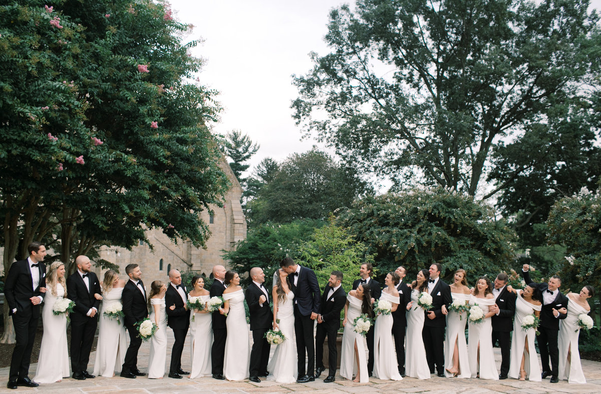 bride and groom celebrating with bridal party wearing all black and white