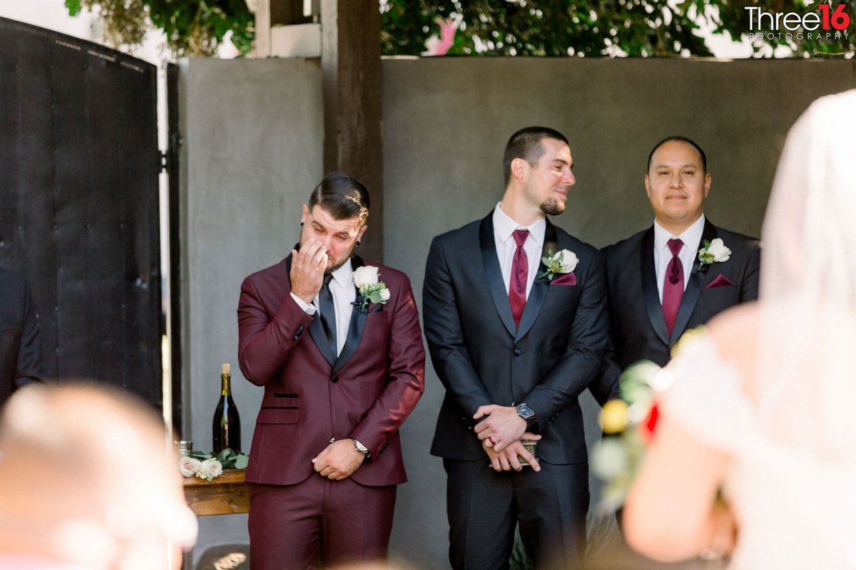 Groom stands at the altar and wipes away a tear as his Bride arrives on the aisle