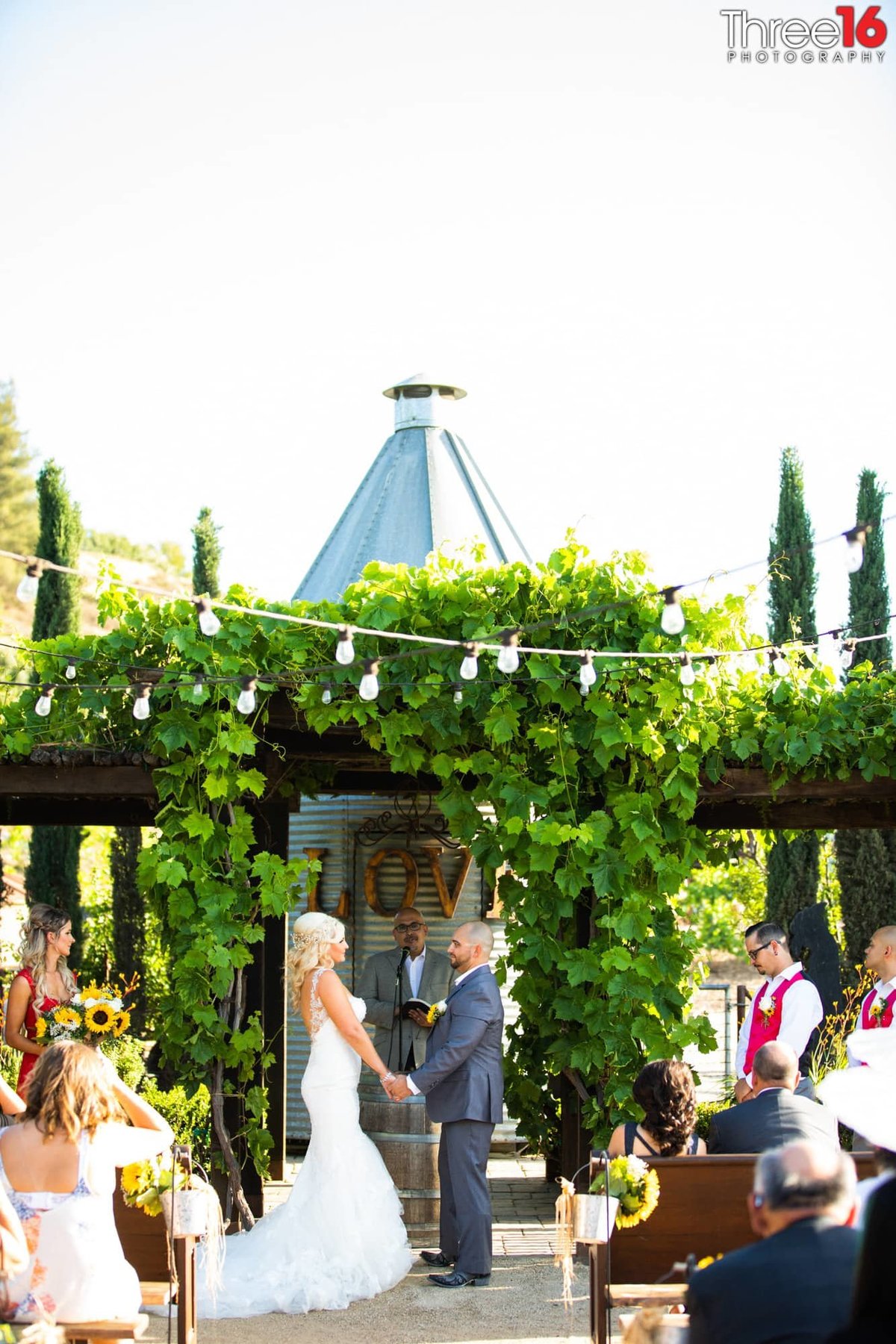 Bride and Groom stand at the altar facing each other and holding hands at the outdoor ceremony at Peltzer Winery