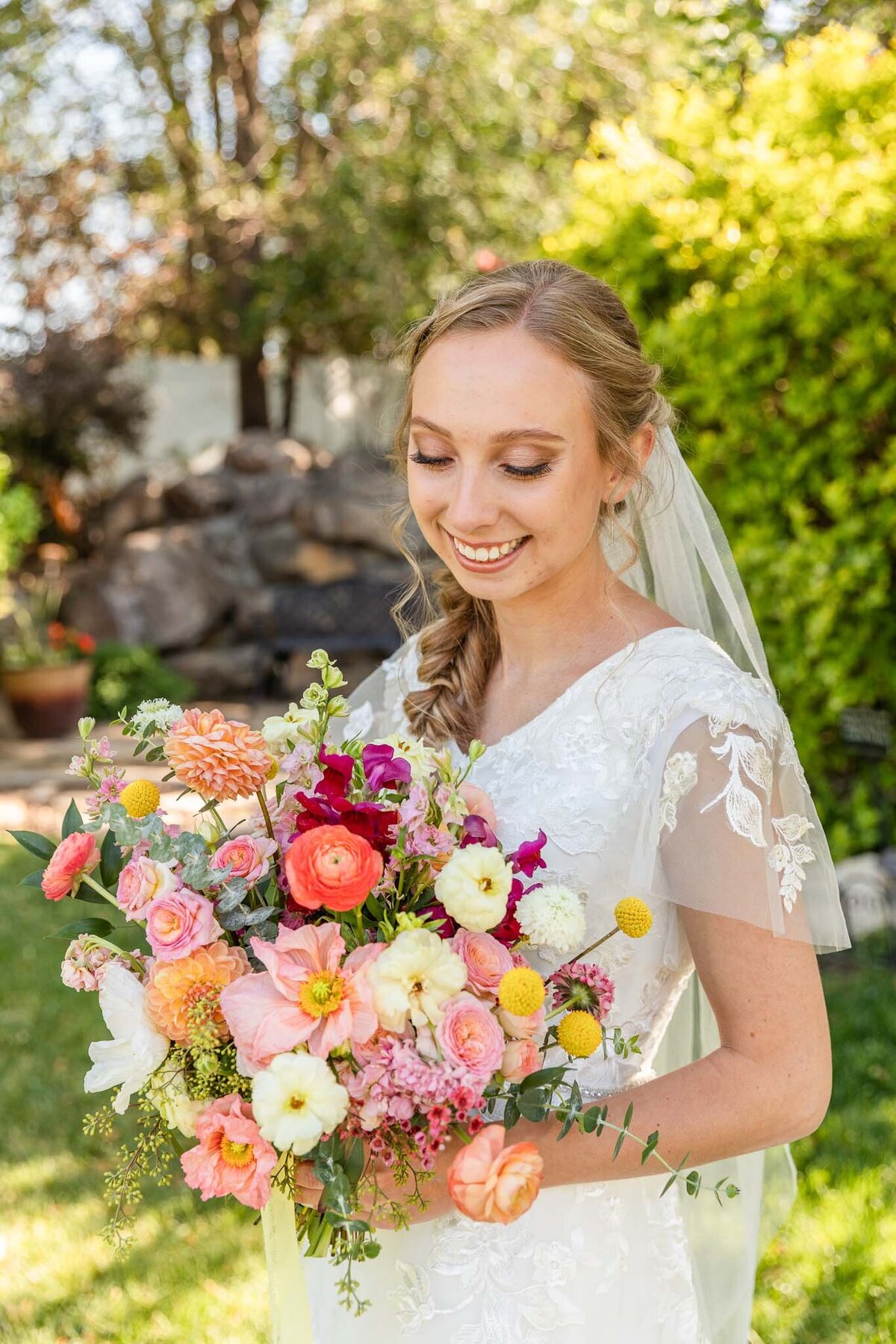 Colorful bridal bouquet with poppies, dahlias, billy balls, ranunculus, and scabiosa.