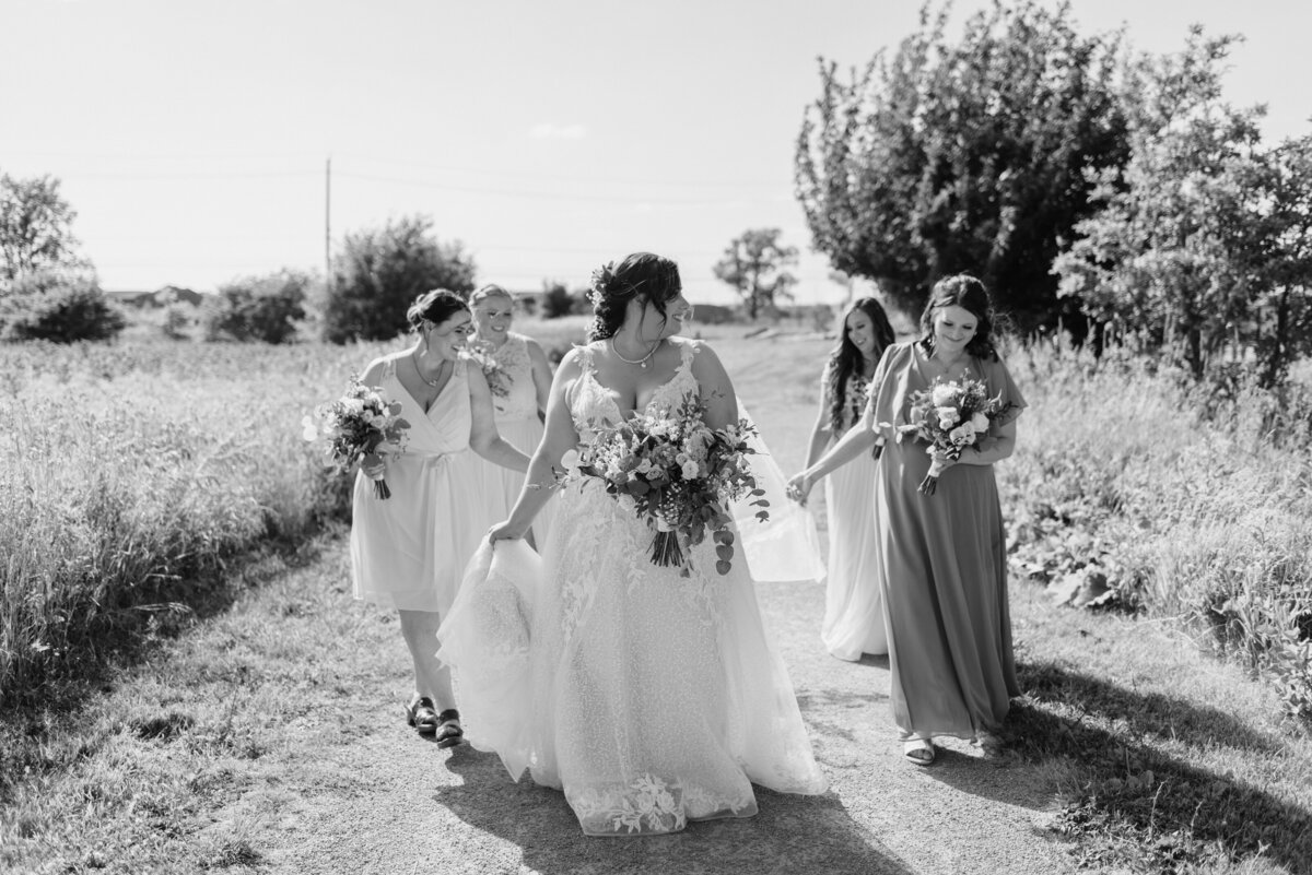 bride walking with her bridesmaids walk in the sun