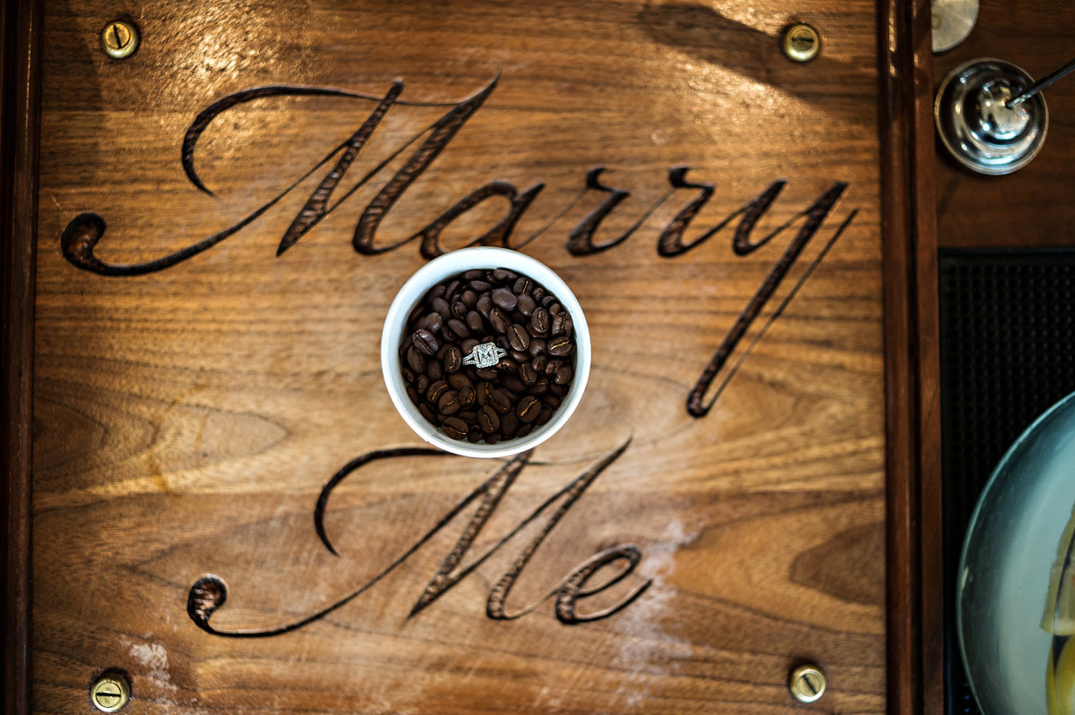 Engagement ring on top of a cup of coffee beans at a local cafe in northern liberties.