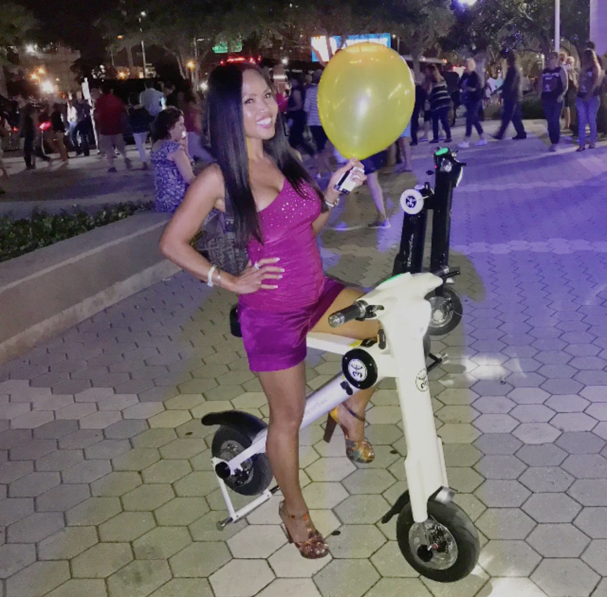 Lady with ballon having night out on the town on White Go-Bike M1