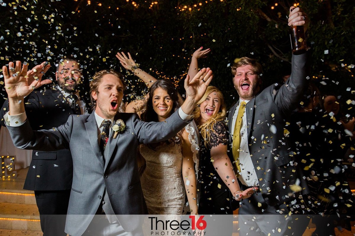Bride and Groom cheer with guests complete with champagne and confetti