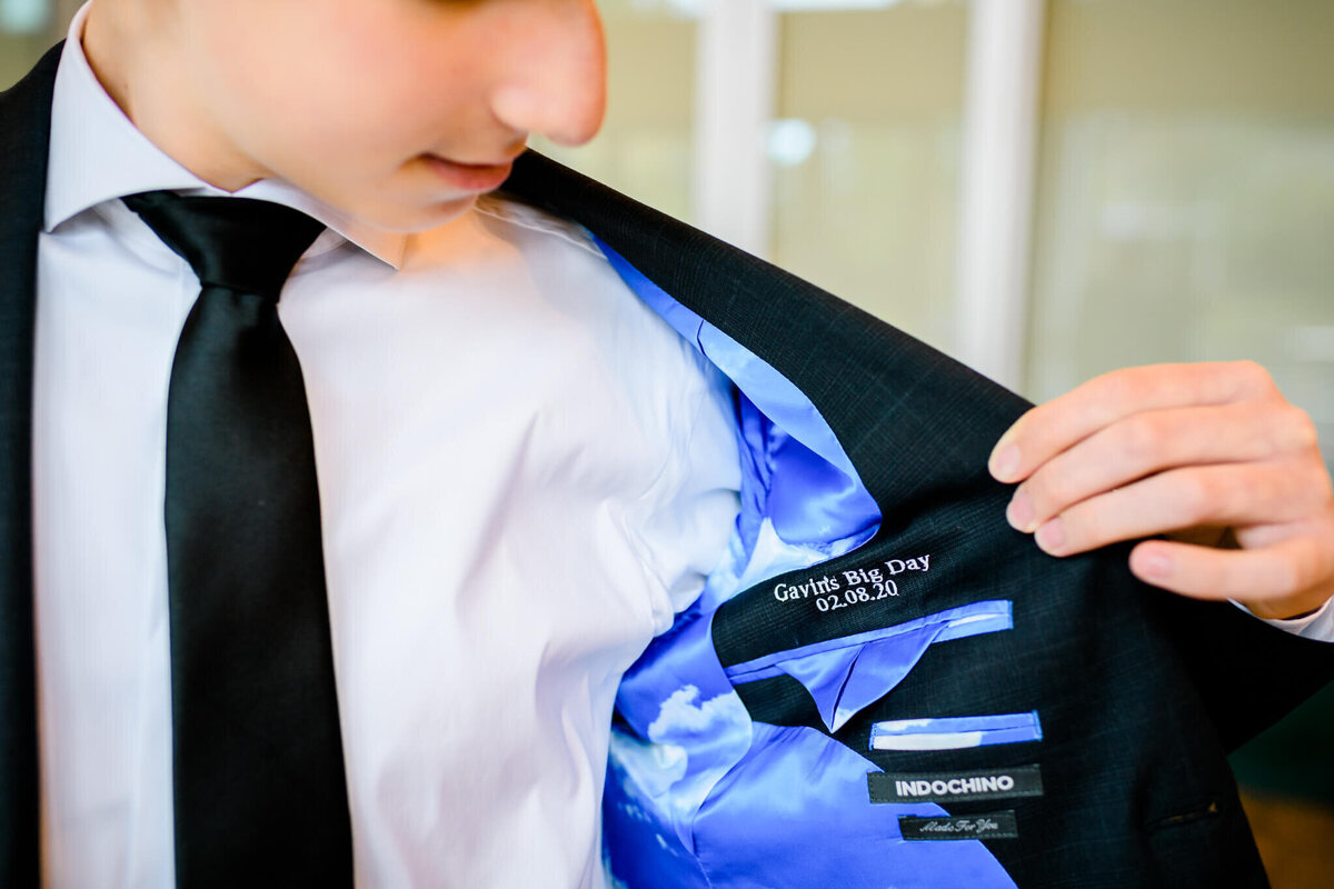 A teen boy shows off his embroidered suit pocket for his Bellevue Bar and Bat Mitzvah Photography