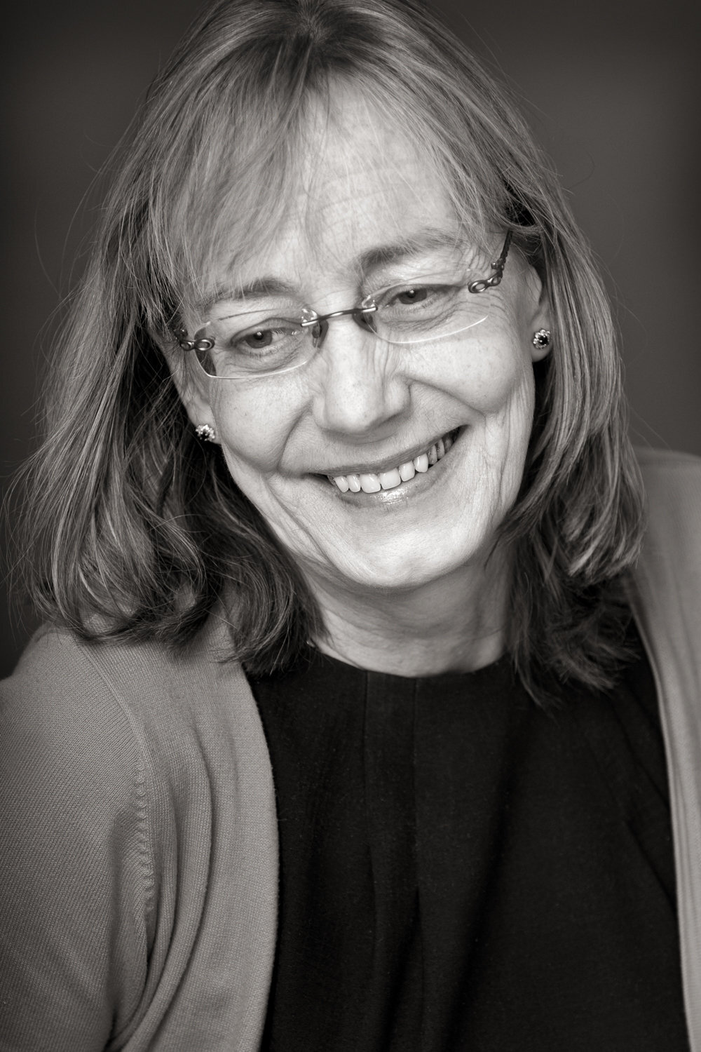Black & white portrait of an  female  doctor wearing glasses and smiling