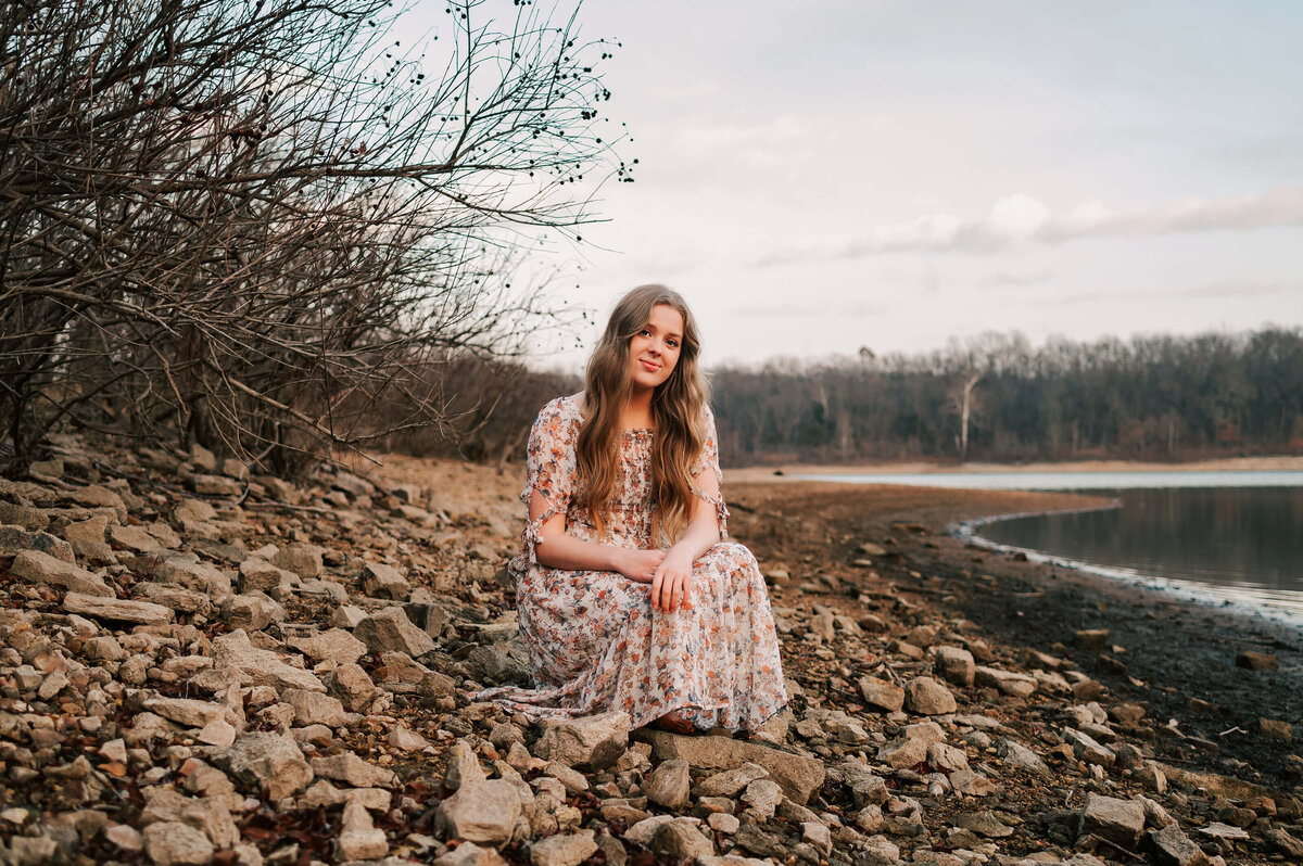 teen girl sitting in rocks next to stockton lake captured by Springfield MO senior photographer Jessica Kennedy of The XO Photography