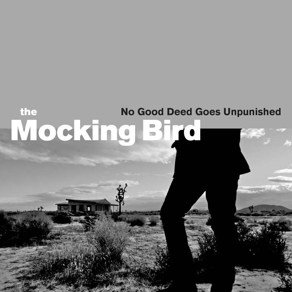 Album Cover Title No Good Deed Goes Unpunished Artist The Mocking Bird top half of image grey legs of singer in foreground standing in desert joshua tree and shack behind him black and white