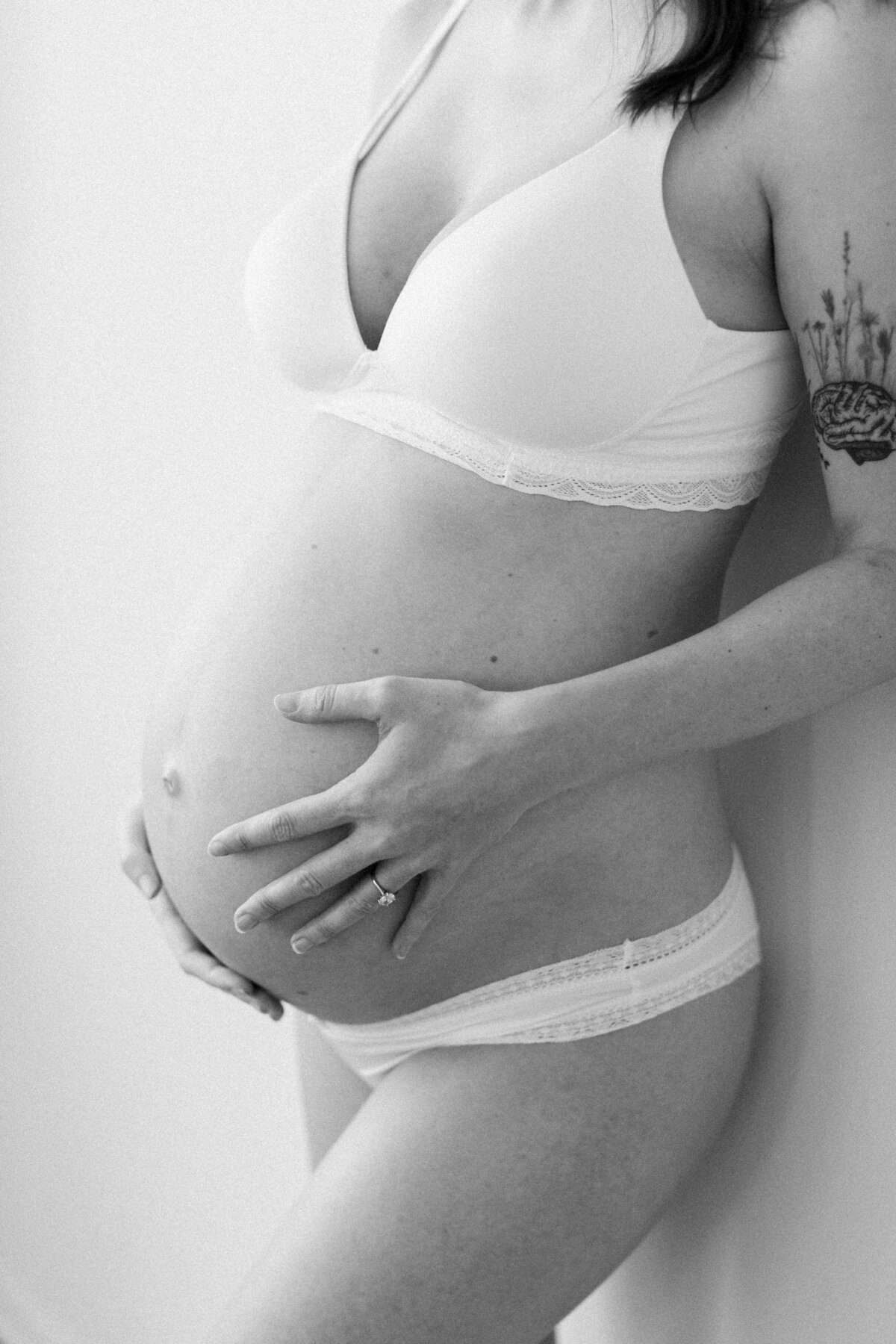 black and white image of woman holding pregnant belly during maternity session in Homer GLen IL